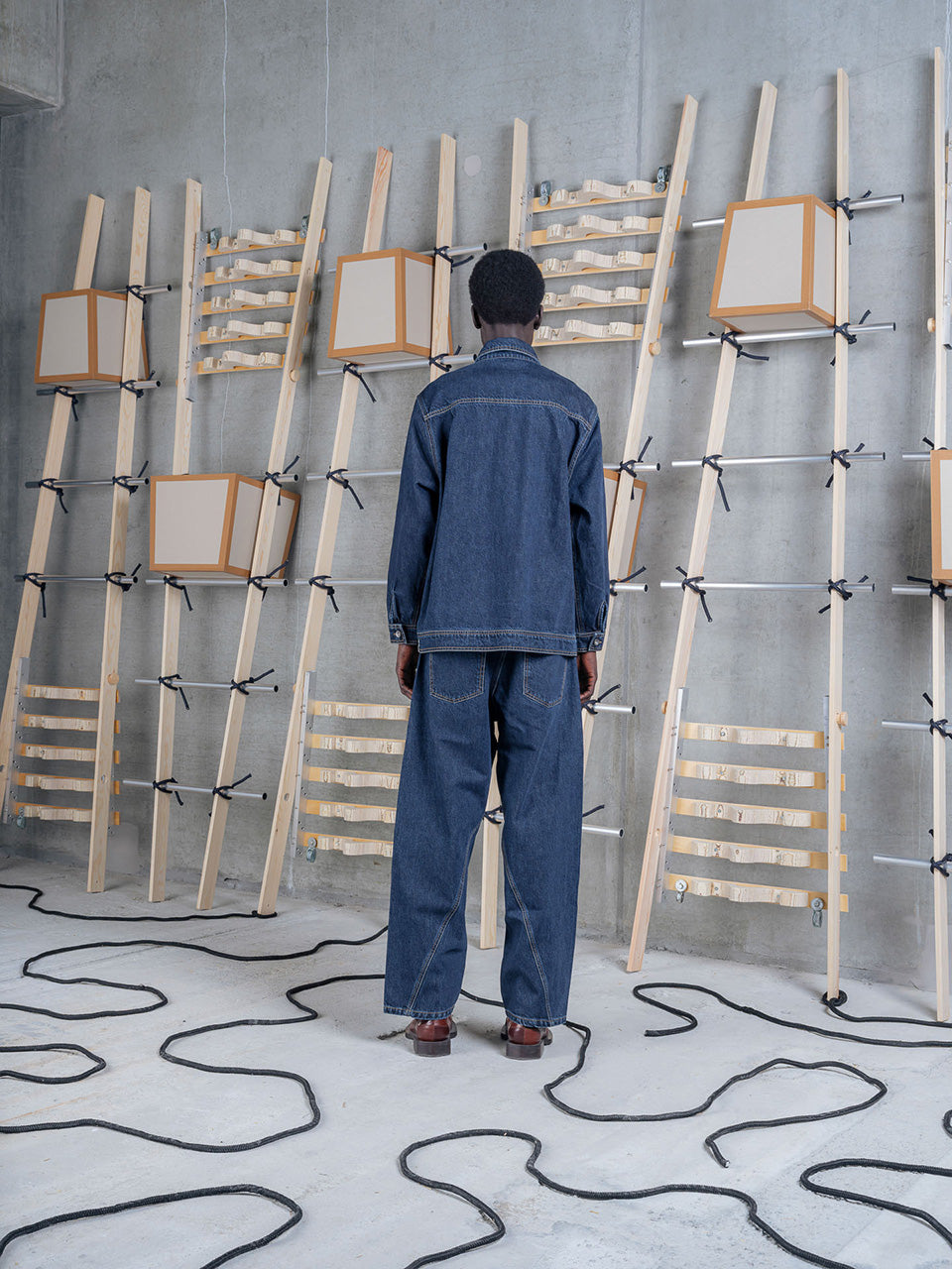 Model wearing Amphi Pants in Rinse Denim by Henrik Vibskov back view