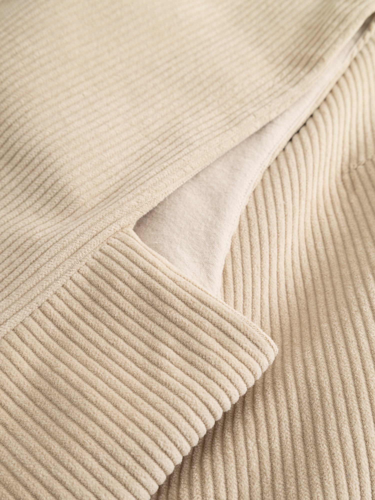 Alternate detail close-up of the Black Crane Corduroy Vest highlighting the side slit detail and soft corduroy structure.