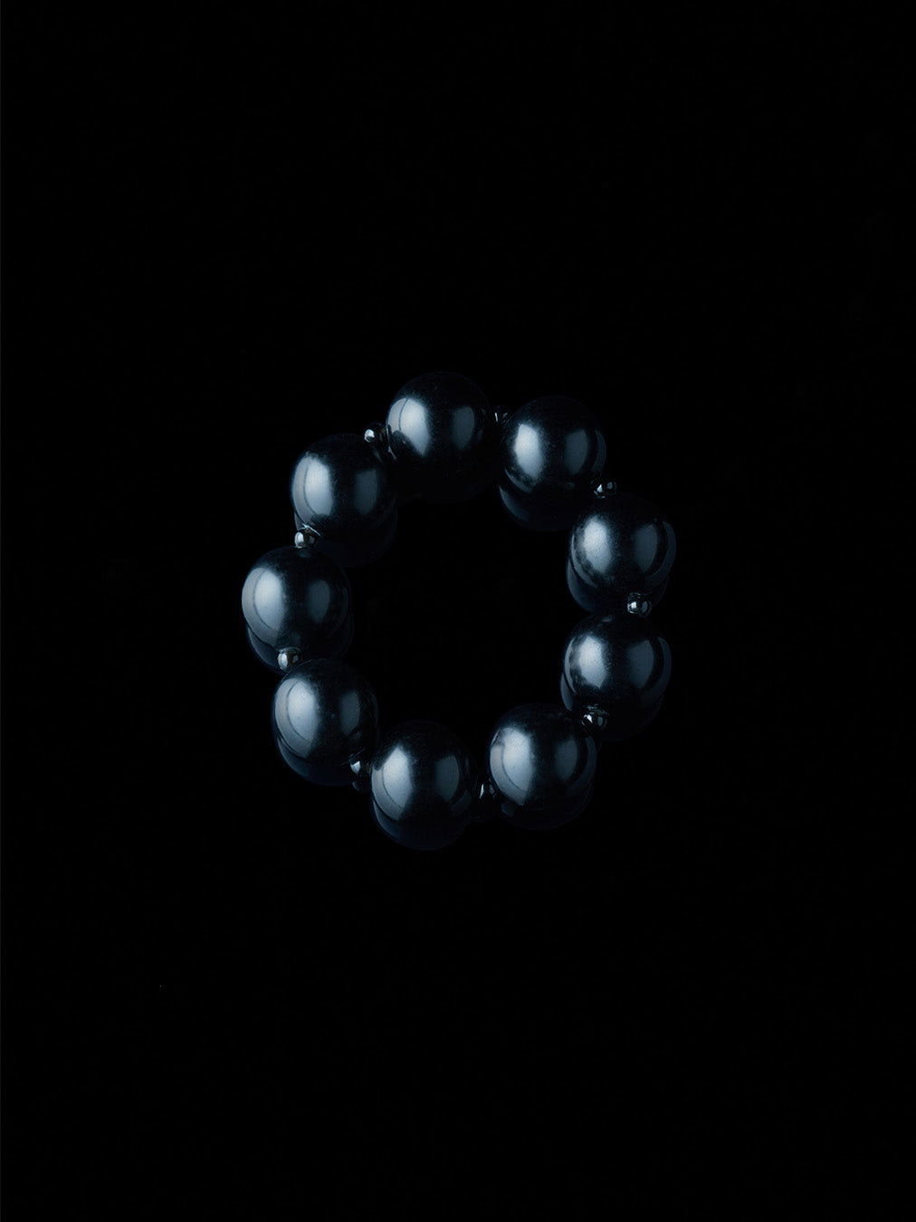 Black and round obsidian bracelet from De Silang on a black background