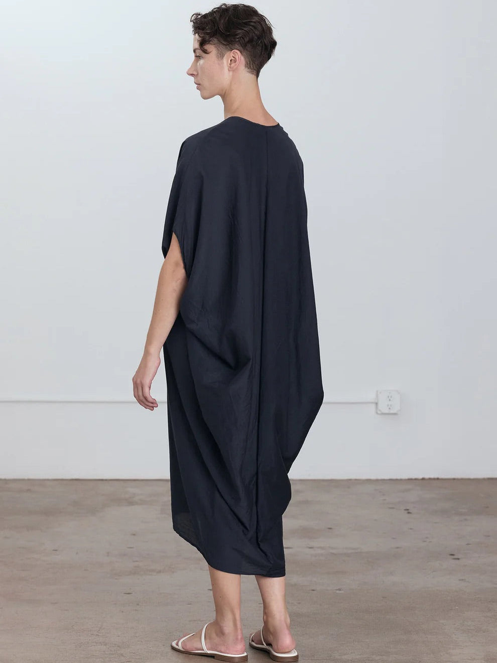 Black Crane Draped Dress in Faded Black - back view on model showing voluminous silhouette and dolman sleeve