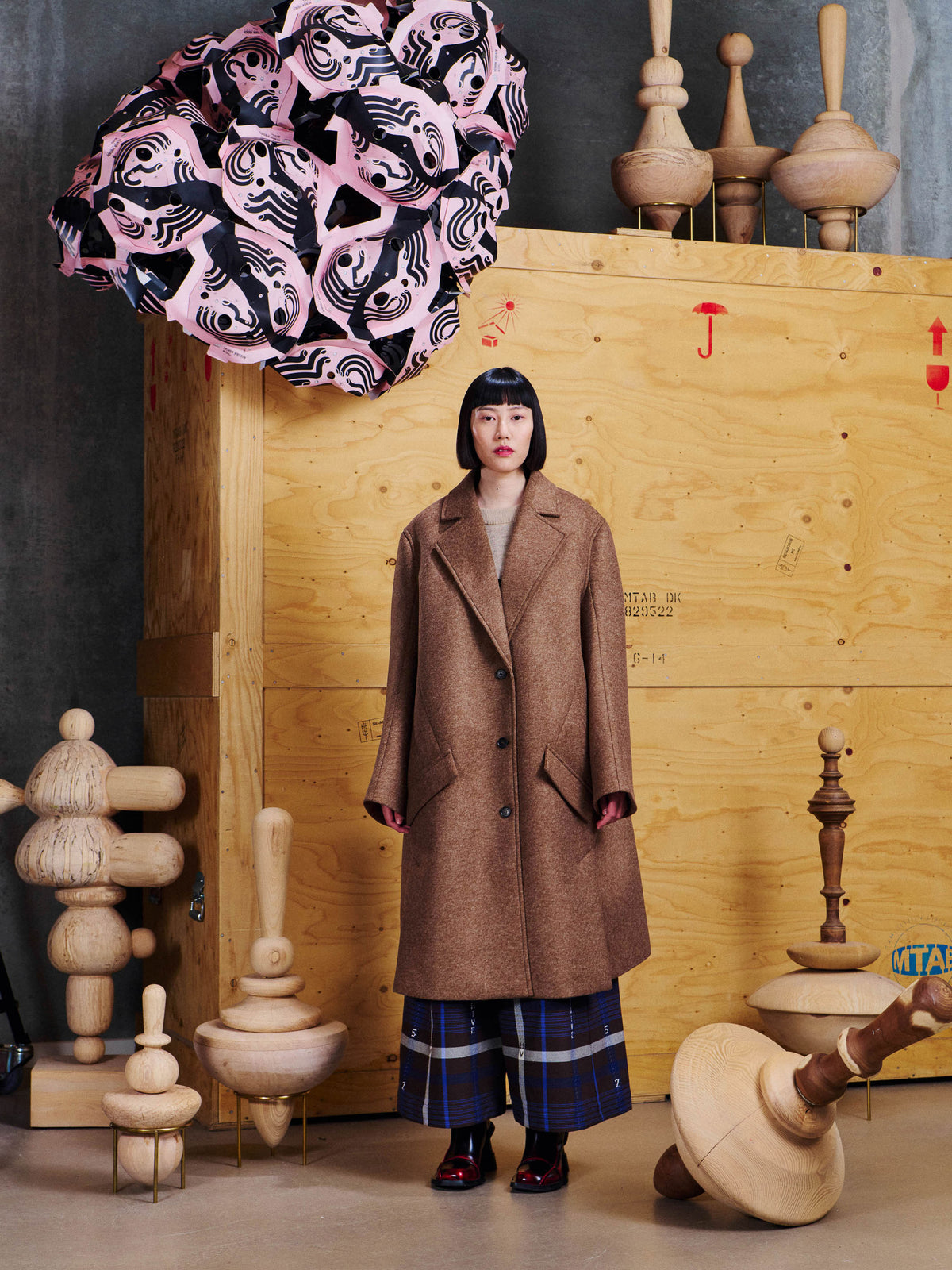 Henrik Vibskov 3D Coat in Camel styled on model, showing relaxed longline fit, wide notch lapels and angled front pockets. ID: ARCHIVE-F601