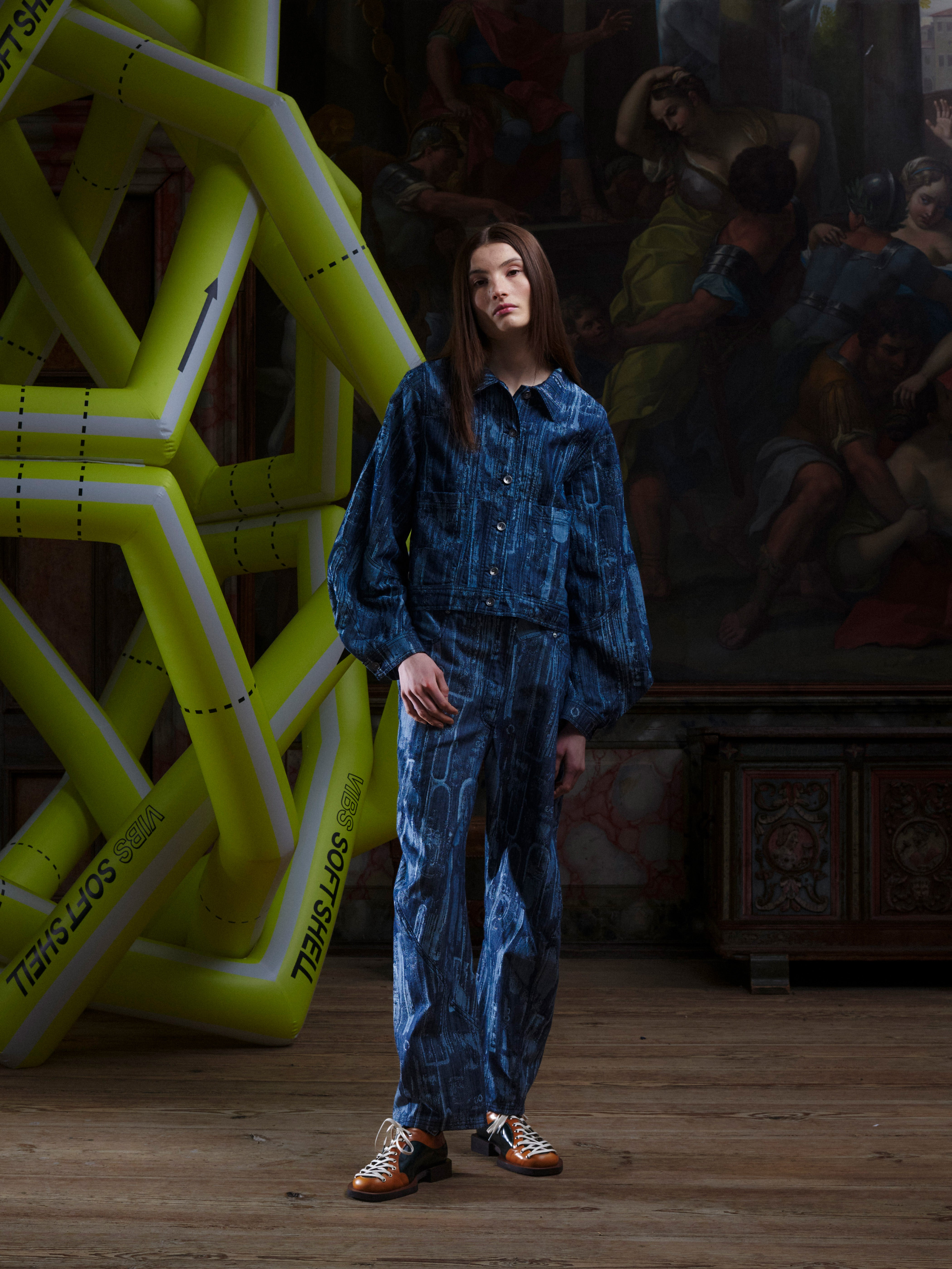 Model wearing the Henrik Vibskov Dial Denim Jacket in grey-blue with an abstract pattern, showing the curved sleeves and cropped silhouette from the front.