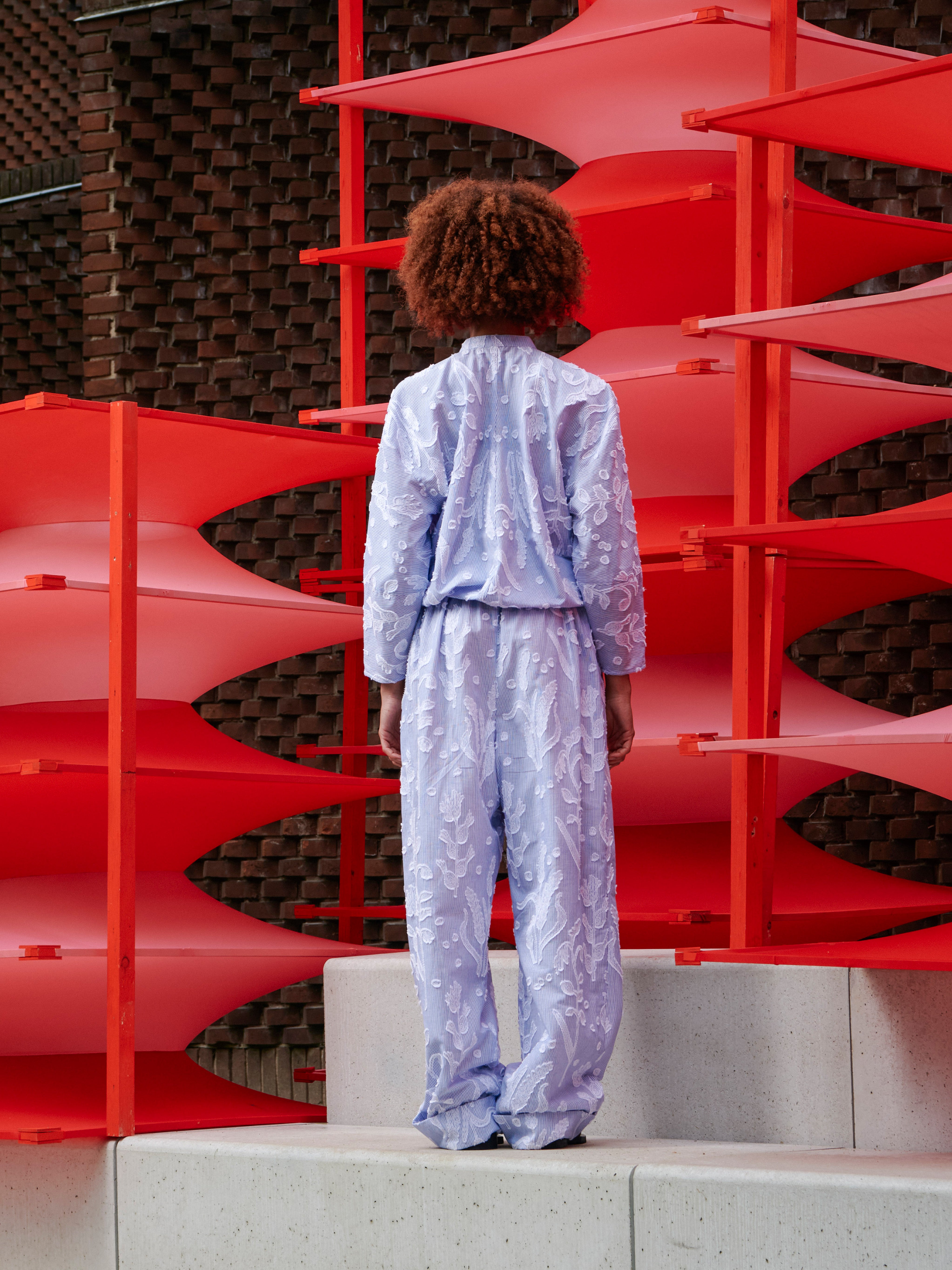 Back view of a model wearing the Flat Shirt, showing the print continuation and loose, relaxed fit.