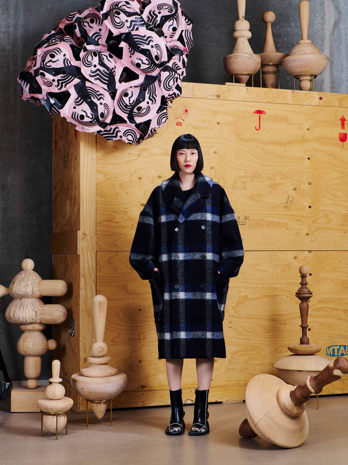Henrik Vibskov Floating Coat in Dark Blurry Checks worn front view, showing the notched collar, dropped shoulders and relaxed long shape.