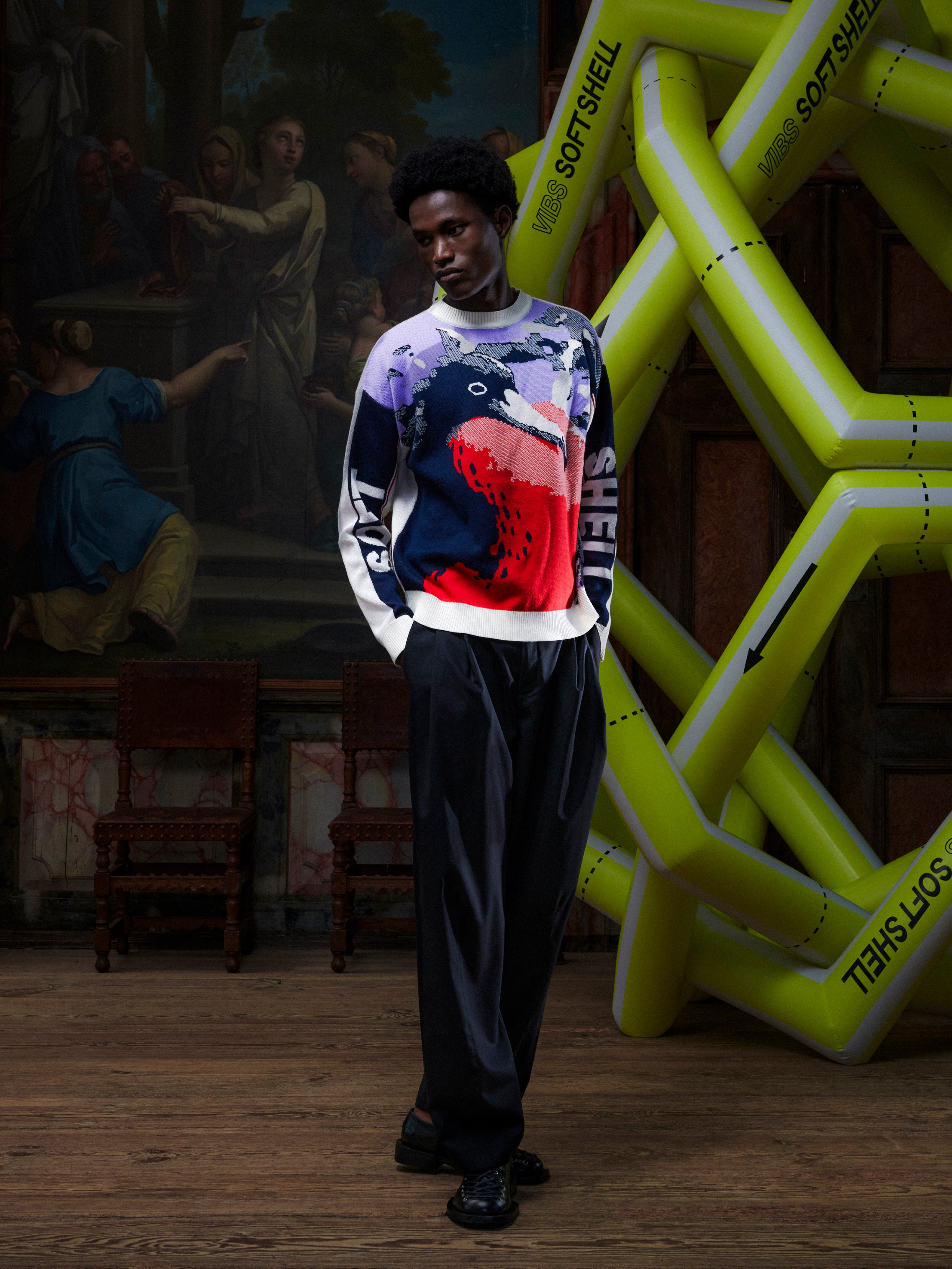 Male model wearing the Henrik Vibskov Frigate Crewneck in Frigate, front view. The model is 191 cm and wears size M, showing the multicolour frigate bird graphic, crewneck shape, and loose fit.