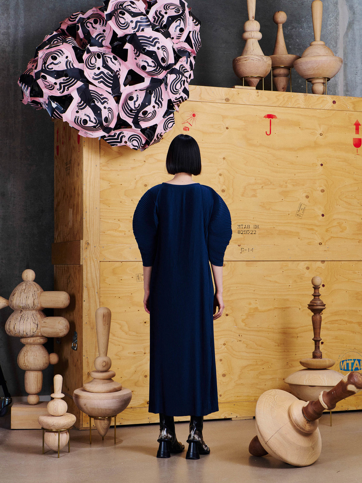 Back view of model wearing the Henrik Vibskov Lupu Plisse Dress in Dress Blues, showing the straight midi silhouette and pleated construction.