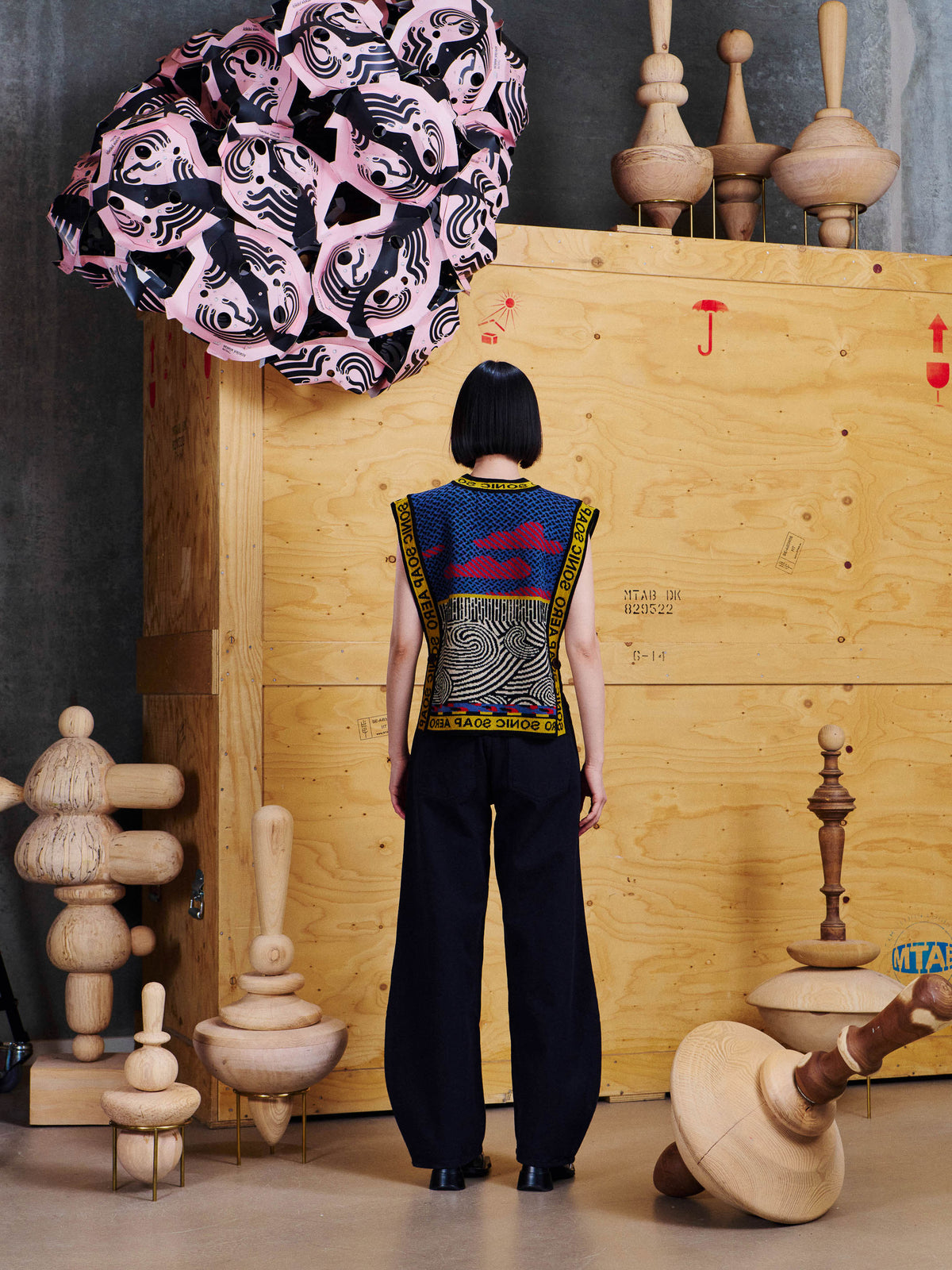 Back view of model wearing the Henrik Vibskov Sail Knit Vest in Stormy Sea, showing the graphic knitted panels, contrast trims and straight silhouette.