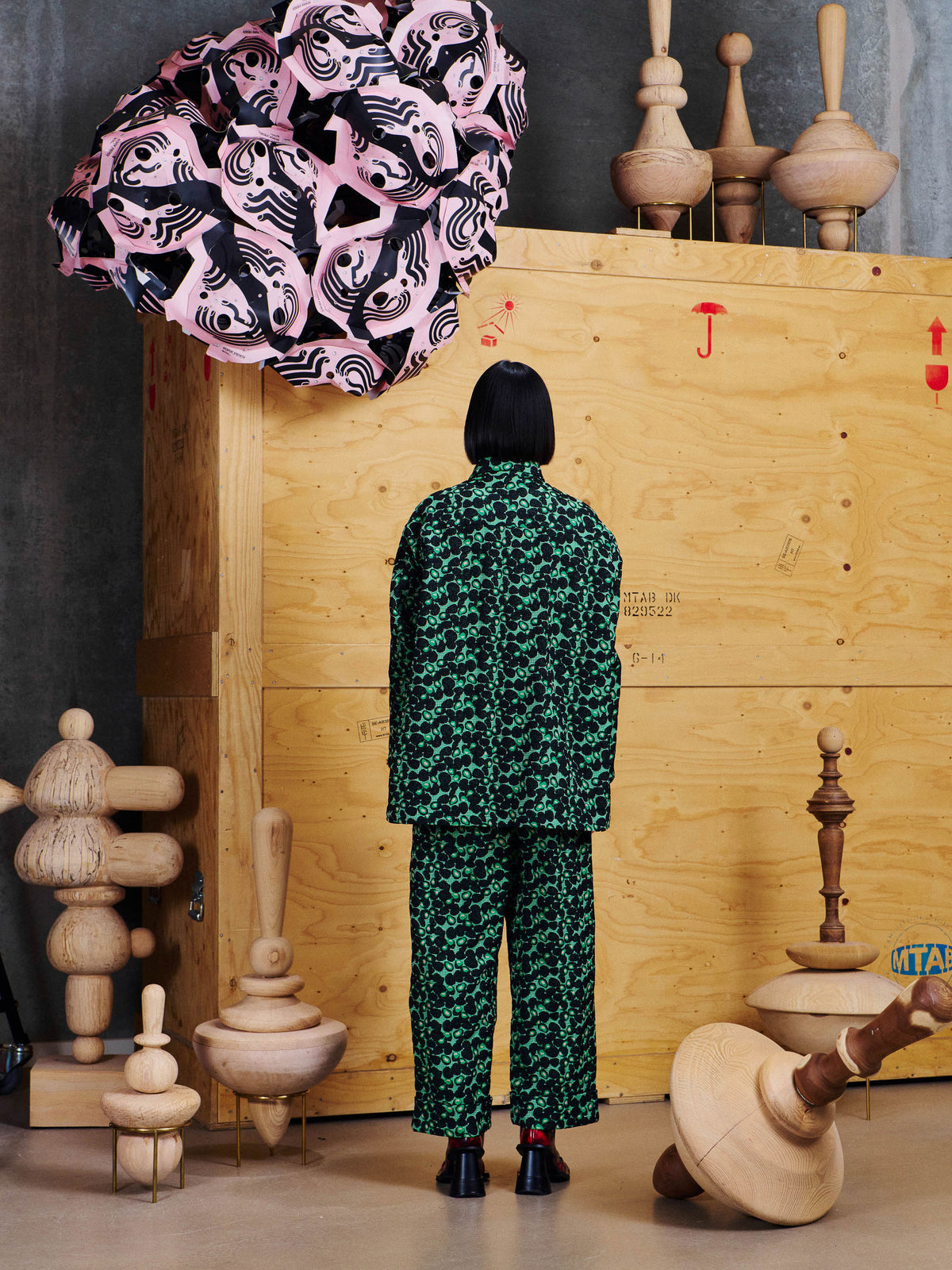 Back view of model wearing the Henrik Vibskov Say Cotton Pants in Dark Green Berries with the matching shirt, showing the straight wide-leg fit.