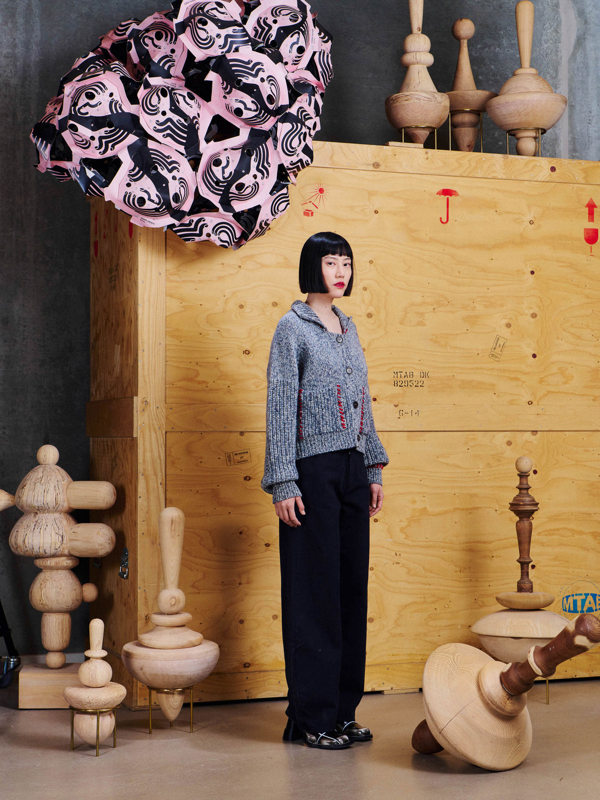 Side view of model wearing the Henrik Vibskov Stitch Cardigan in Red Stitch Grey Melange, showing the wide collar, long sleeves and relaxed silhouette.