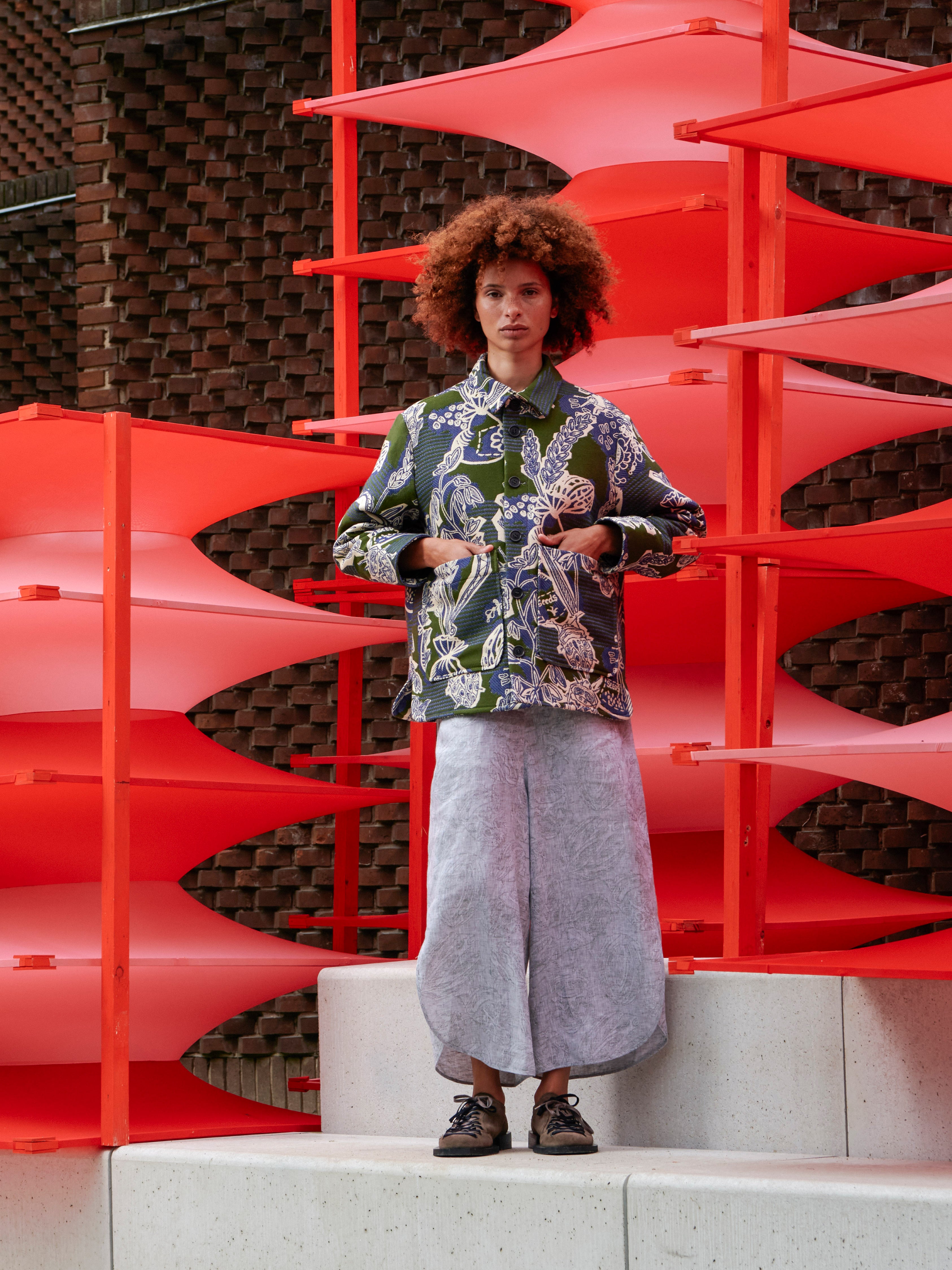 Model wearing the Wheel Jacket in Garden of EEden green blue and white floral boxy jacket with front button closure and patch pockets, front view – Henrik Vibskov Spring/Summer 2026 Key Collection