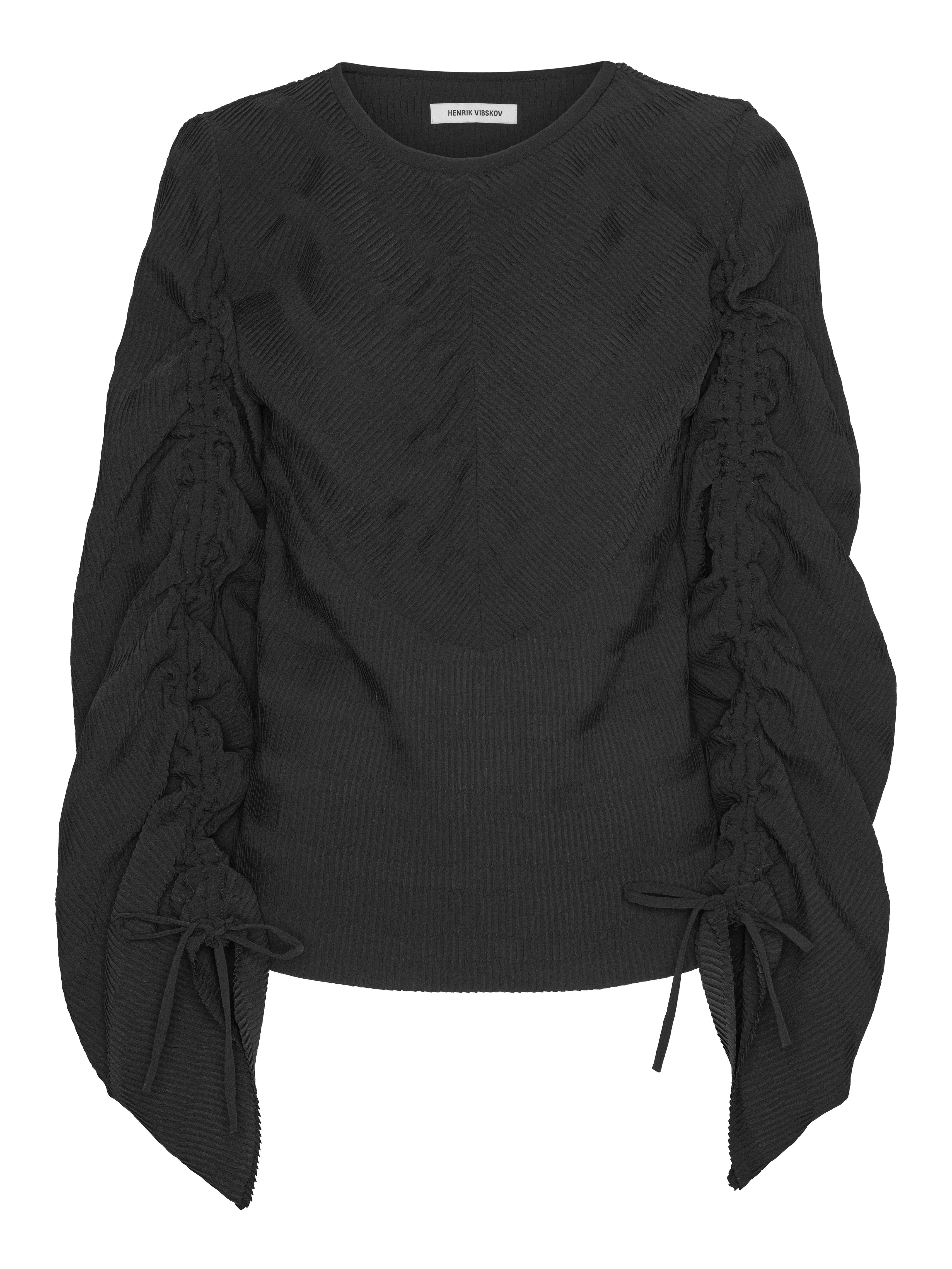 Pleated blouse with adjustable drawstring sleeves from Henrik Vibskov on a white background