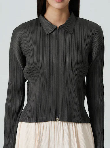 Model wearing the Issey Miyake PLEATS PLEASE! August AW26 Blouson in Charcoal, showing the fitted pleated silhouette and collar.