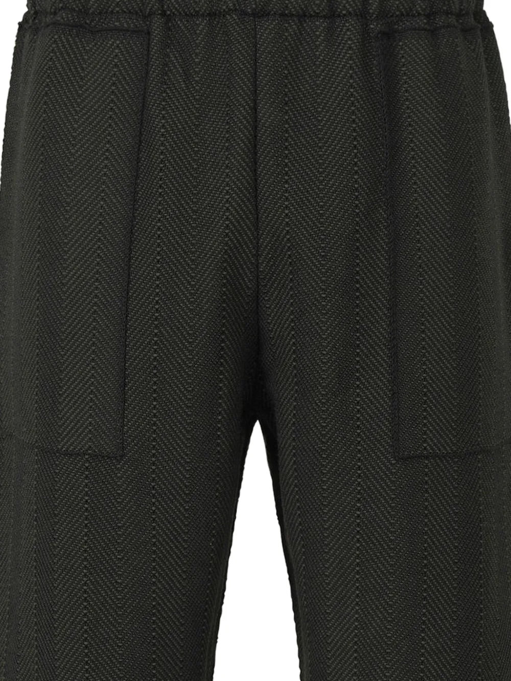 Close-up of herringbone knit texture and front patch pocket on the February SS26 Inlaid Knit Pants in Black – Issey Miyake Homme Plissé