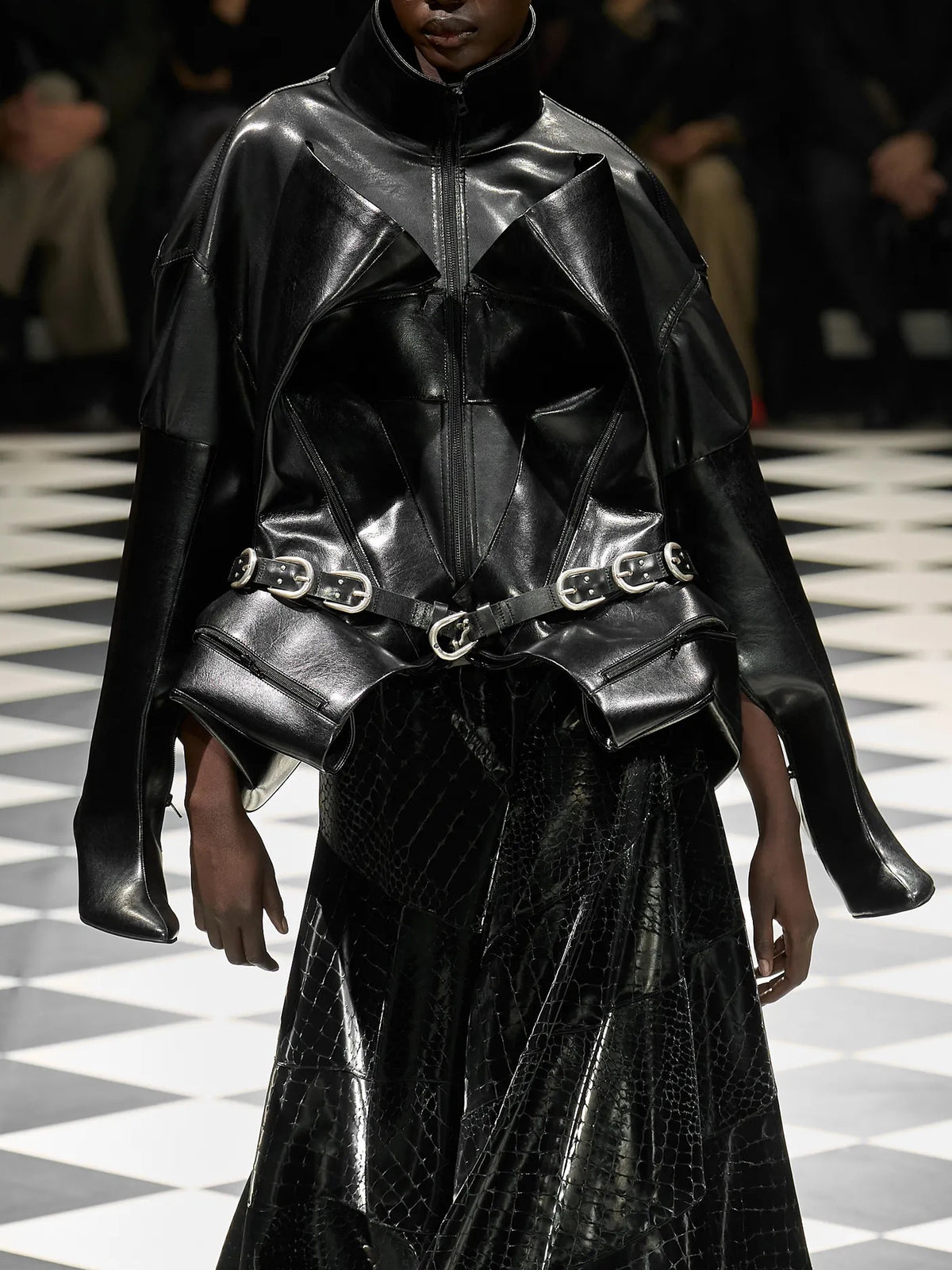 Junya Watanabe Belted Jacket in Black worn on the runway, showing the structured front construction, high collar and multi-buckle waist belt.