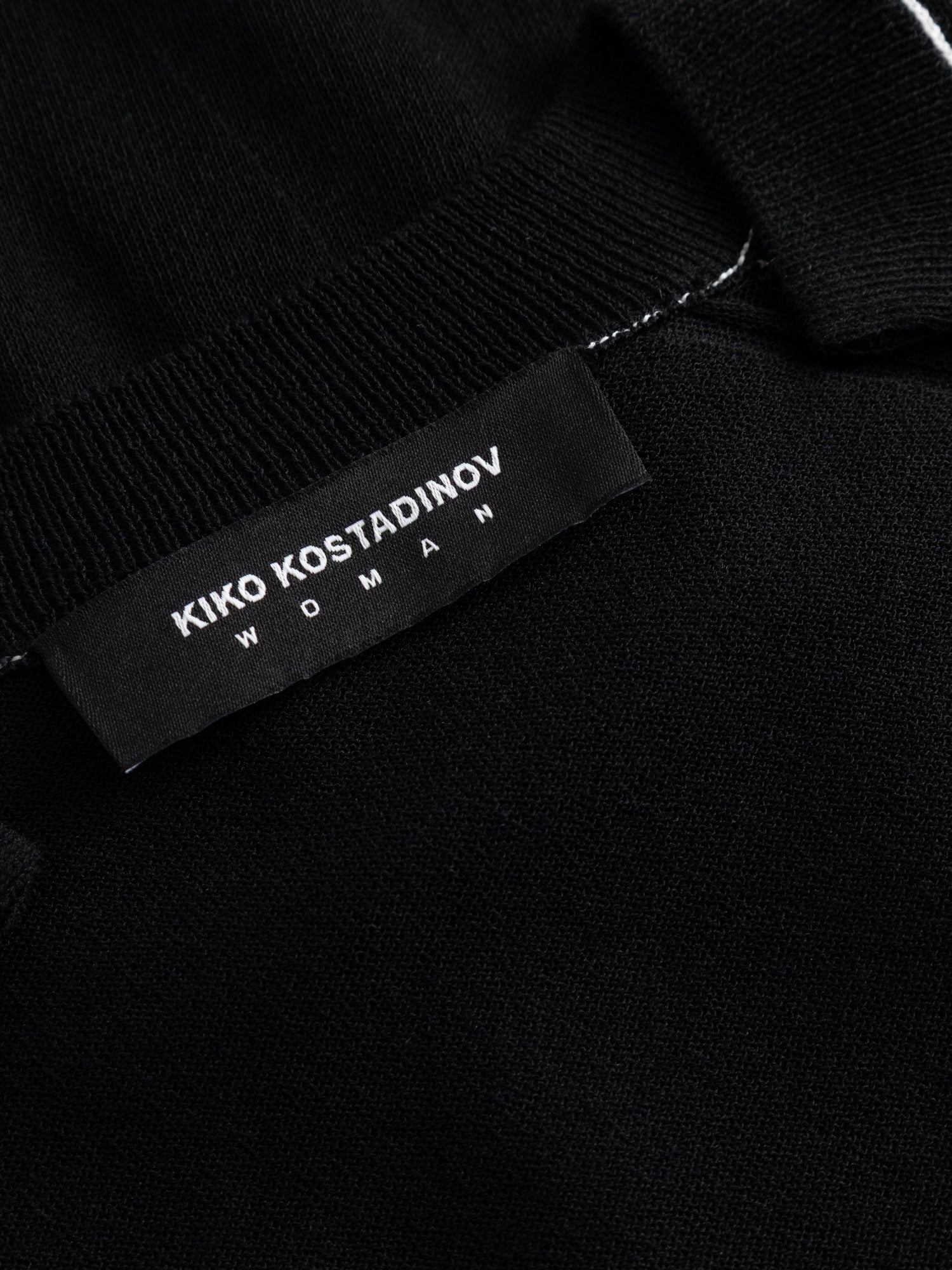 Kiko Kostadinov Woman Kreiner Knit Cardigan, close-up of the woven "Kiko Kostadinov Woman" label at the ribbed neckline