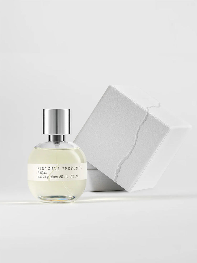 Perfume bottle with its white box packaging on a light background