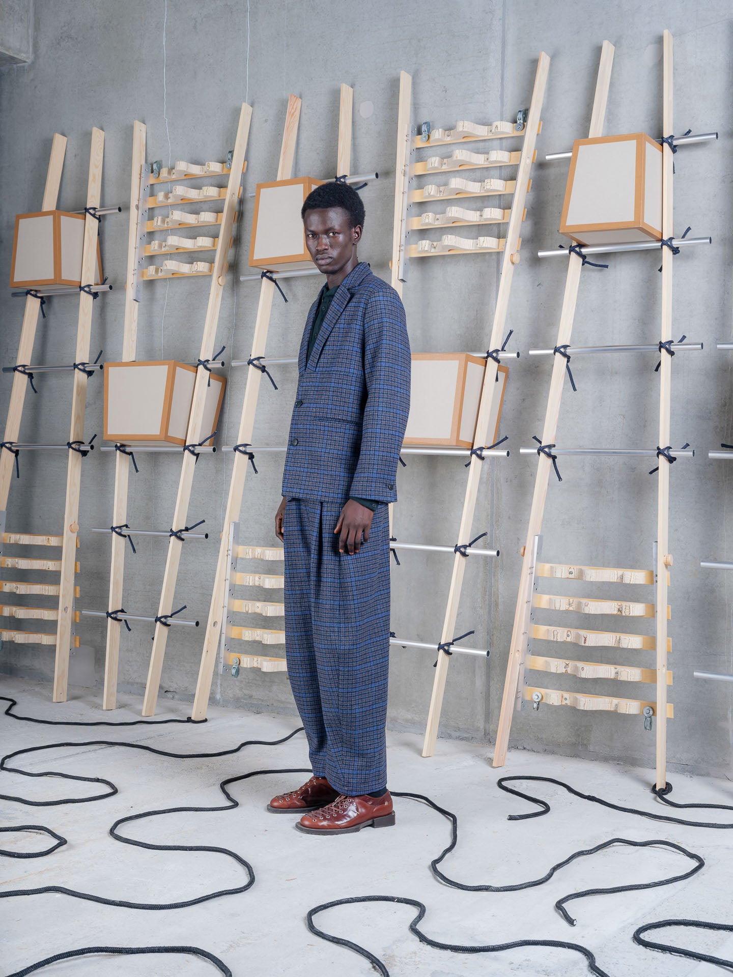 Model wearing Henrik Vibskov Lonely Blazer in Blue Wool Checks, side view.
