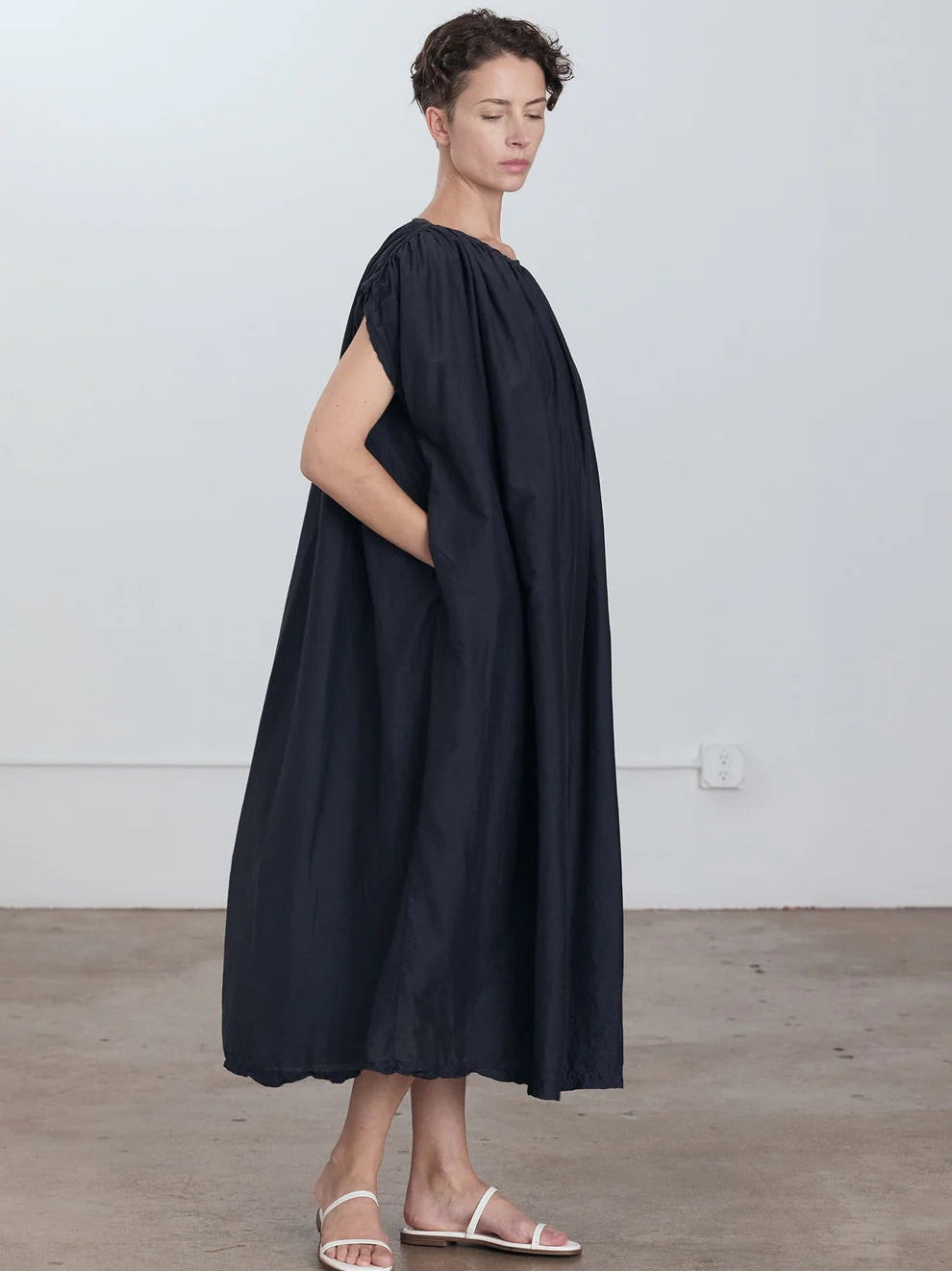 Black Crane Mont Blanc Dress in Faded Black - side view on model showing voluminous oversized silhouette and midi length