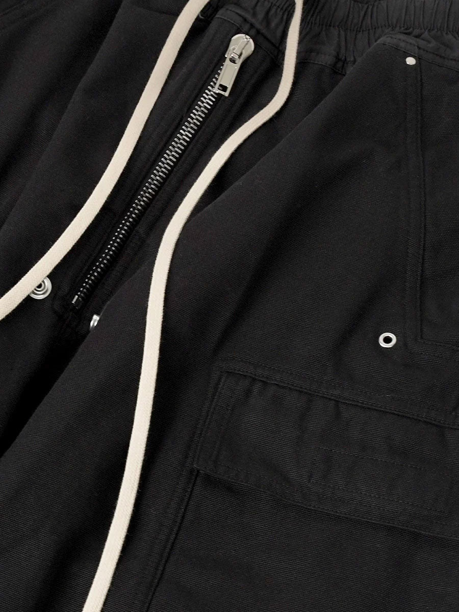 Close-up of Rick Owens DRKSHDW Double Cargo Jumbo Belas in Black showing drawstring waistband, front zip fastening, rivets and cargo pocket