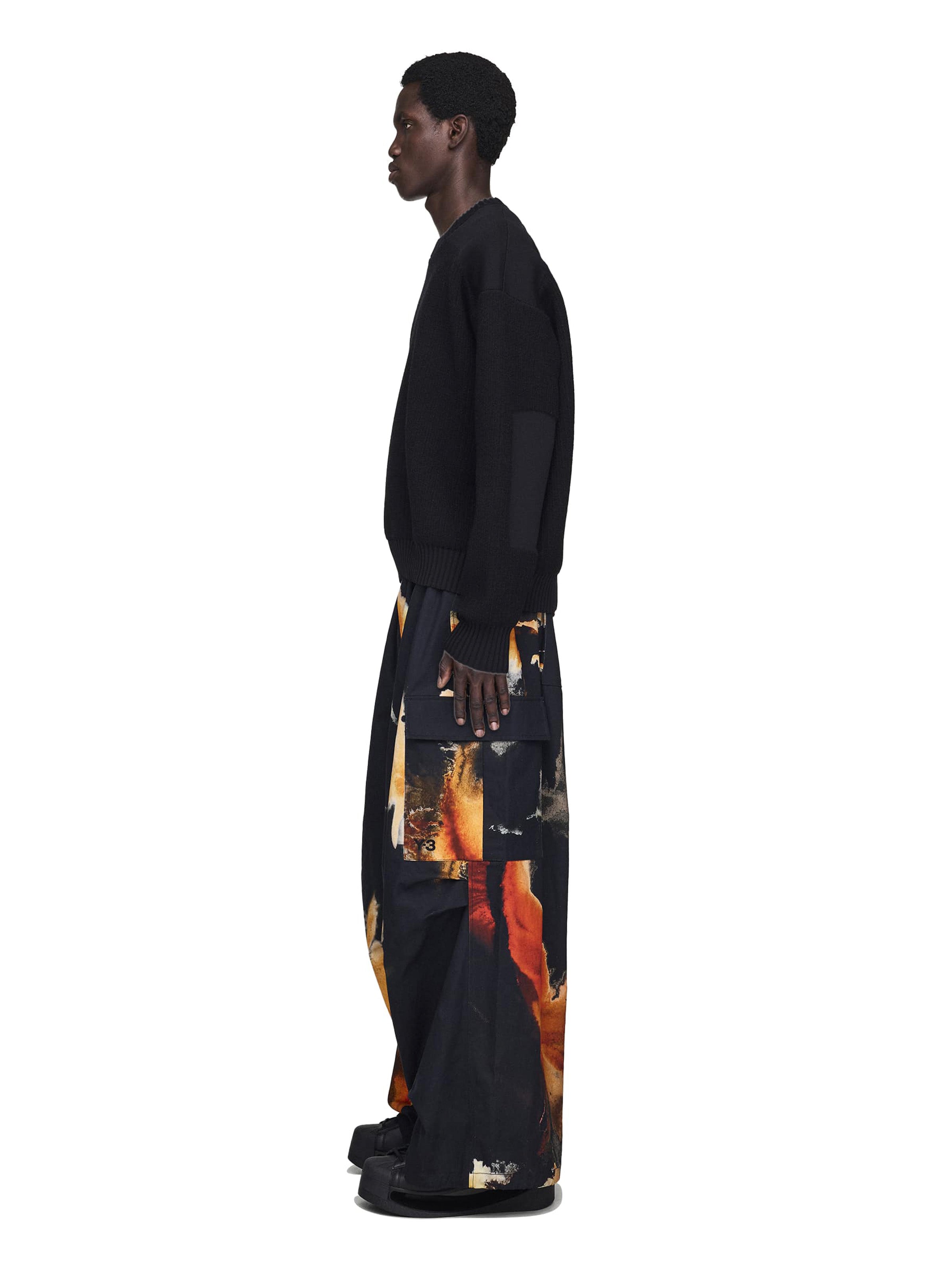 Person wearing a black outfit with a colorful pants on a white background