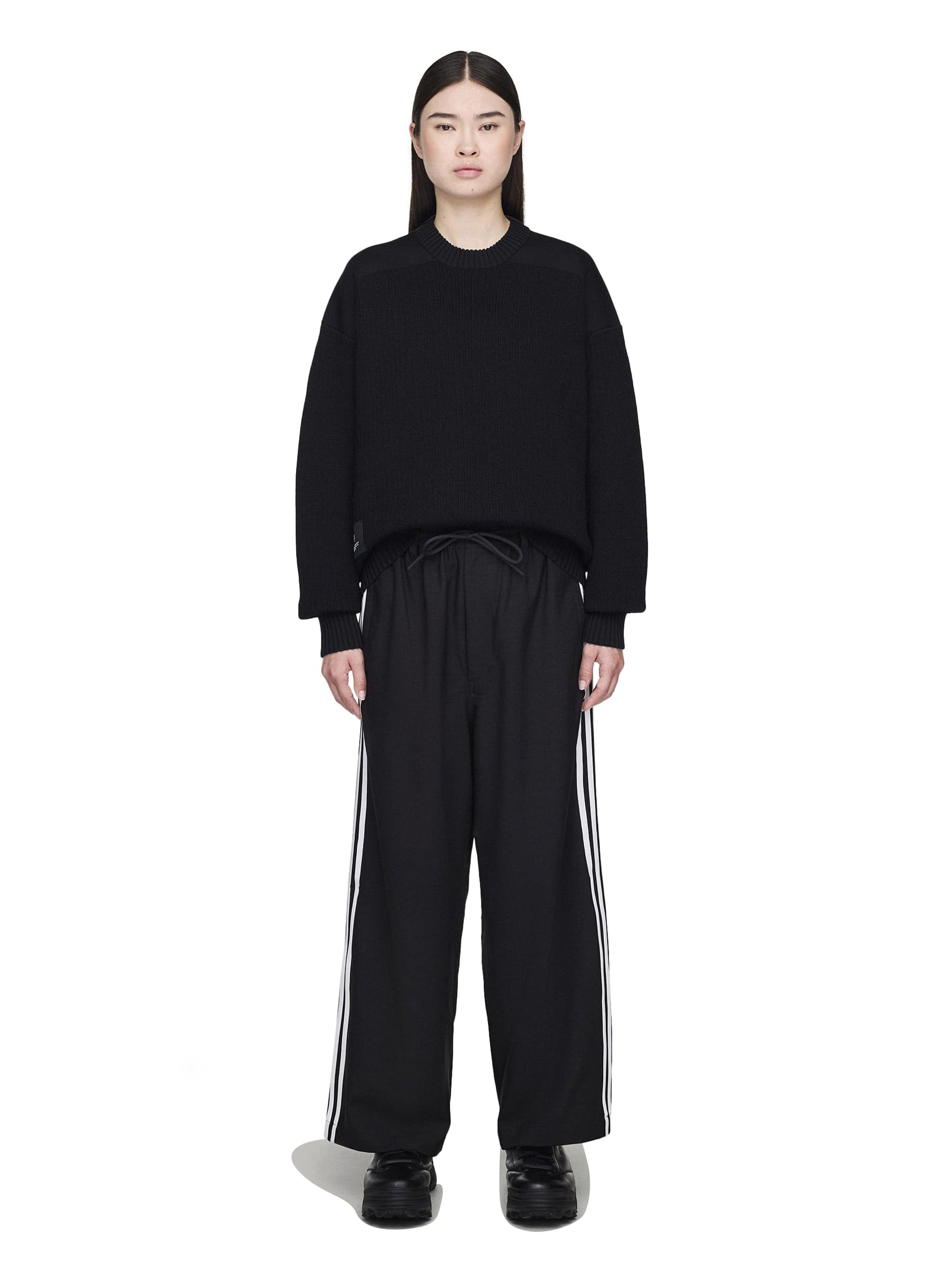 Person wearing a black outfit with white stripes on a white background