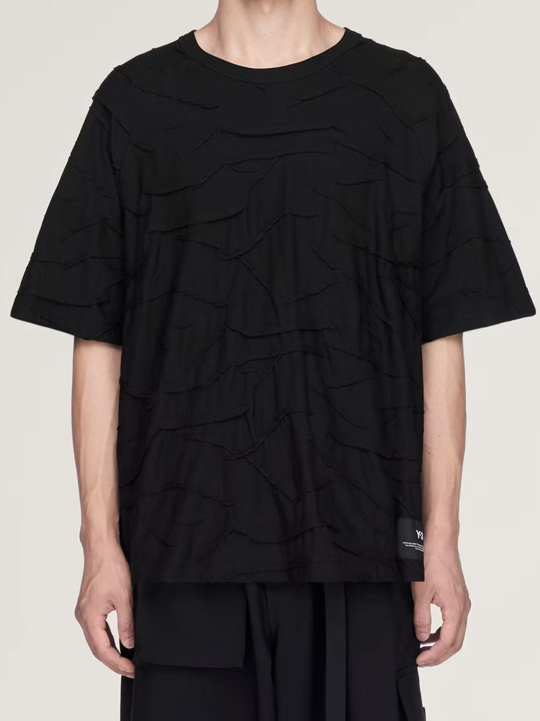 Model wearing the Y-3 Pleated Short Sleeve Tee in black, showing the regular fit, textured jacquard surface and short sleeves.