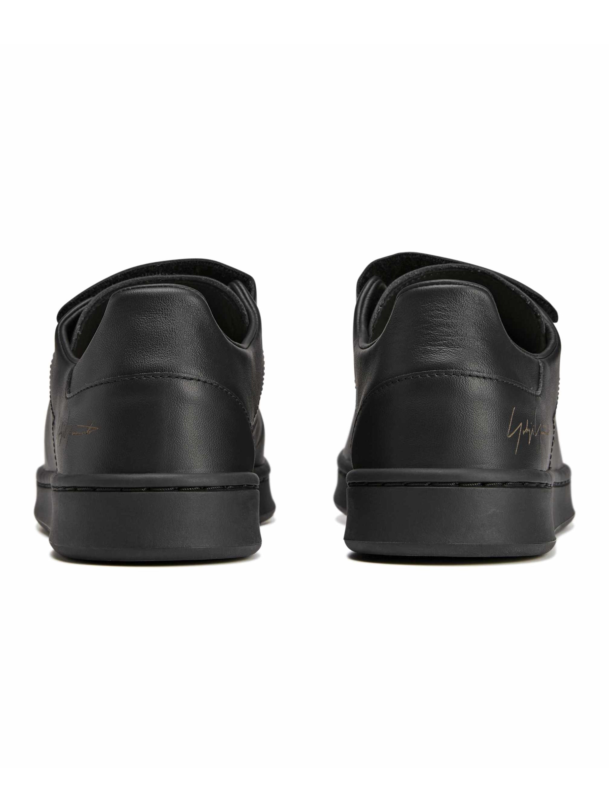 Back view packshot of the Y-3 Stan Smith Hook-and-Loop Shoes in Black, highlighting the heel shape and designer signature detail.