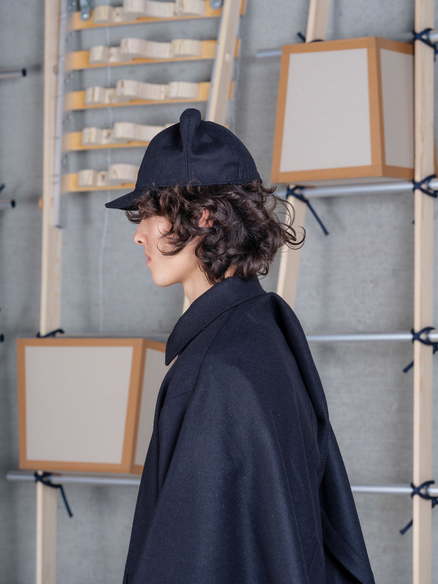 Model wearing Cara Eyed Cap in Black by Henrik Vibskov side view
