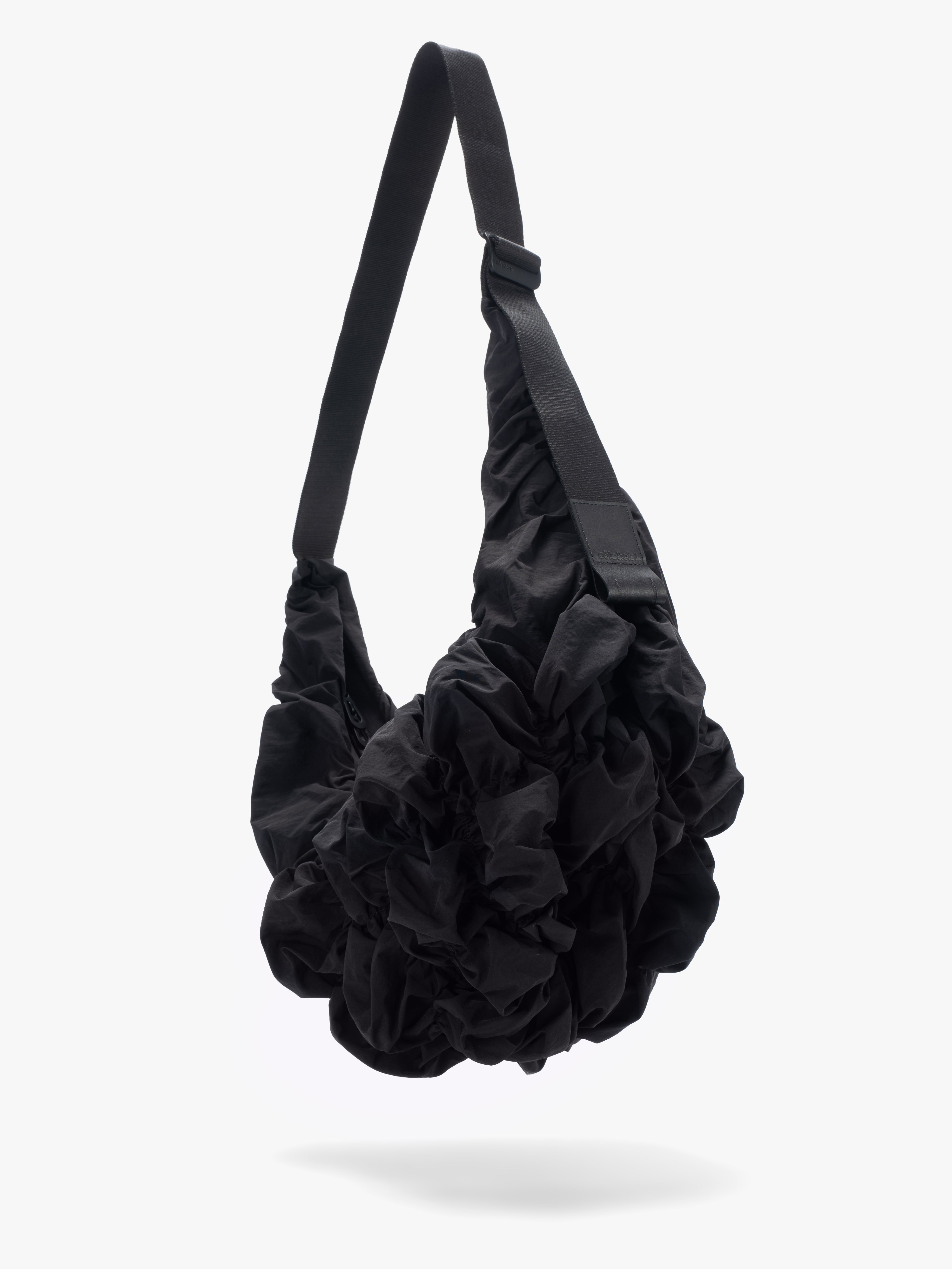 Côte&Ciel Hyco S Otra Gathered crossbody bag in black, angled view from below showing sculptural design and ergonomic contours.
