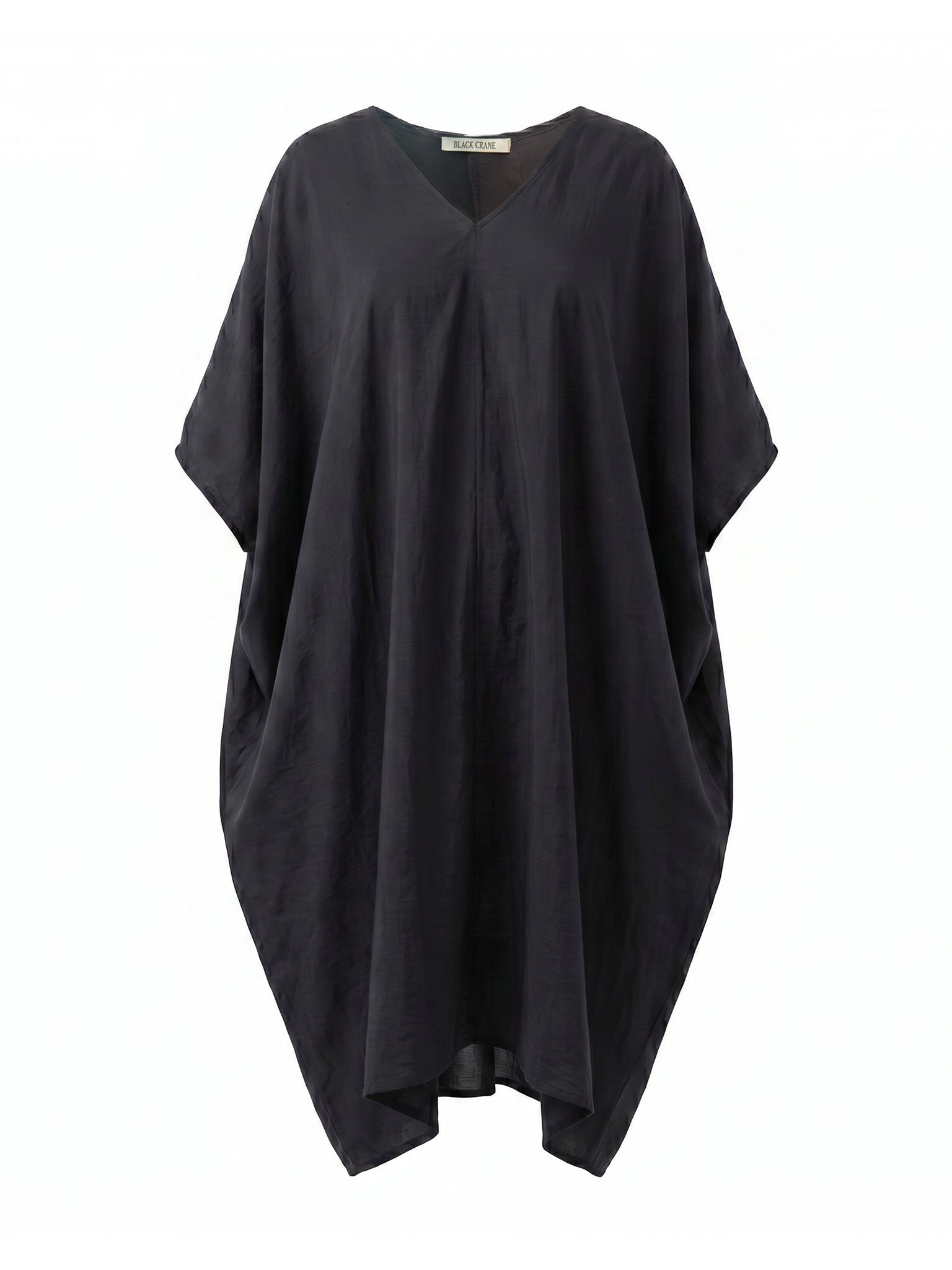 Black Crane Draped Dress in Faded Black - flat lay showing voluminous silhouette and v-neck with outbinding in silk cotton blend
