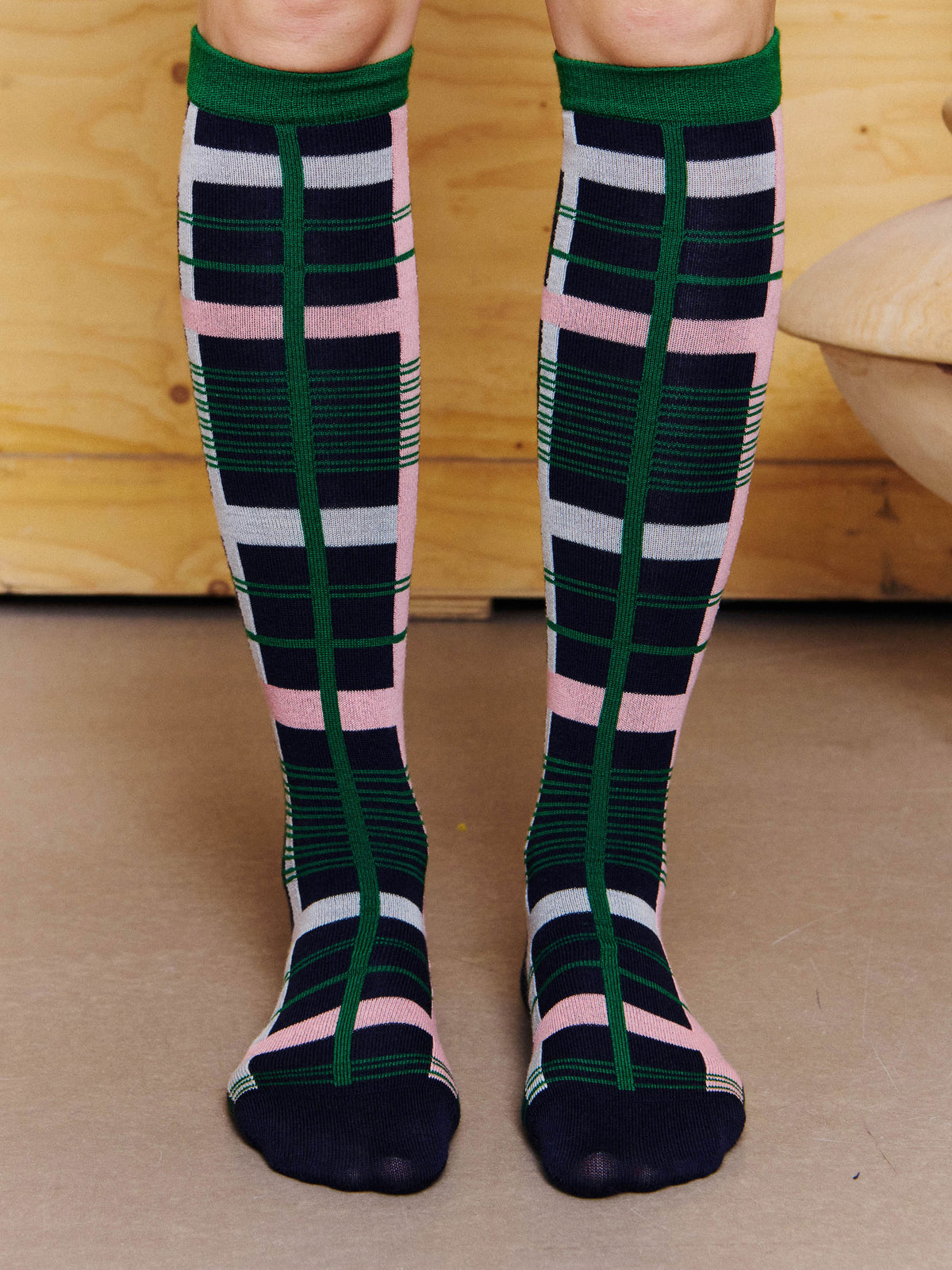 Henrik Vibskov Archive Socks in Green Pink Archive worn front view, showing the knee-high fit, green cuffs and all-over check pattern.
