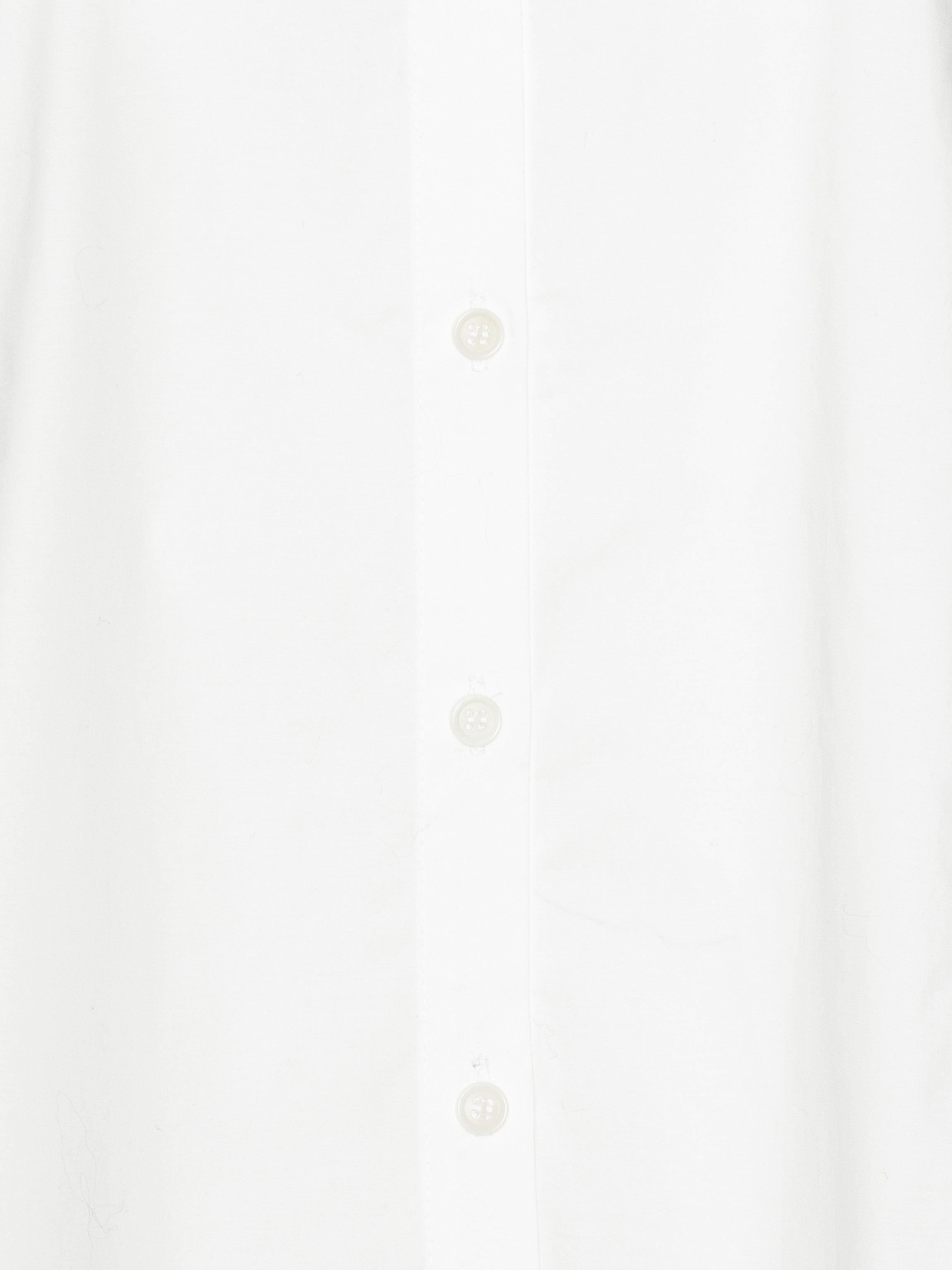 Close-up of a white shirt with white buttons on a white background