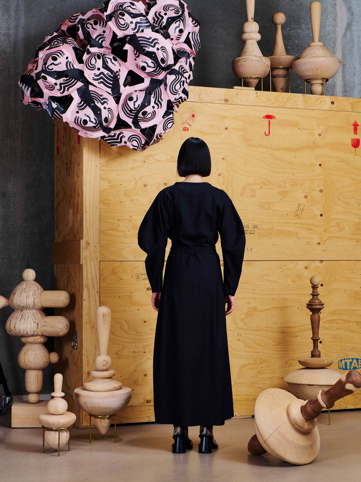 Back view of model wearing the Henrik Vibskov Crackle Dress in Black, showing the tied waist, long skirt and voluminous sleeve shape.
