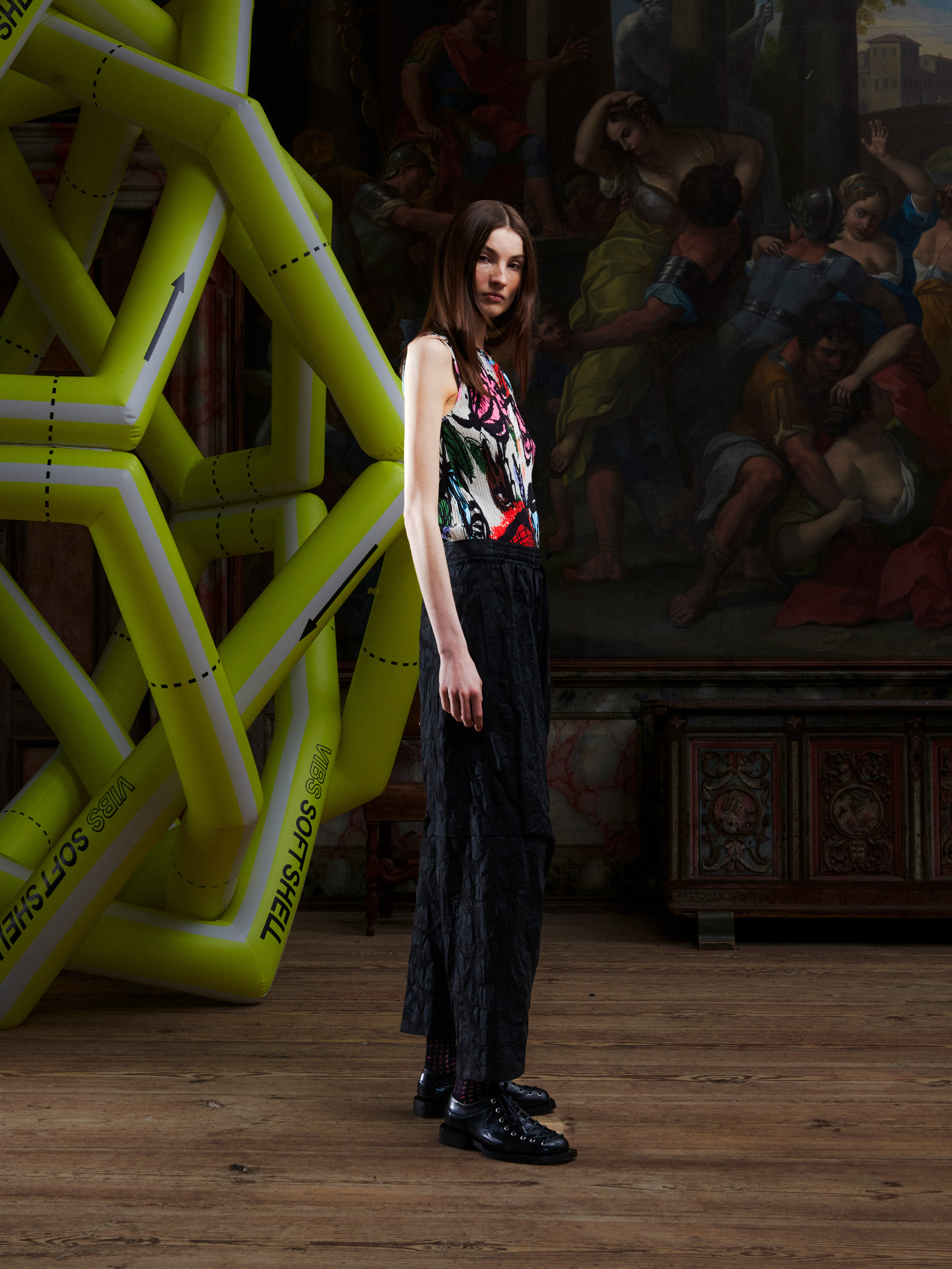 Side view of female model wearing the Drawstring Pants in Black Amulets, highlighting the straight-leg shape and tonal amulets pattern.