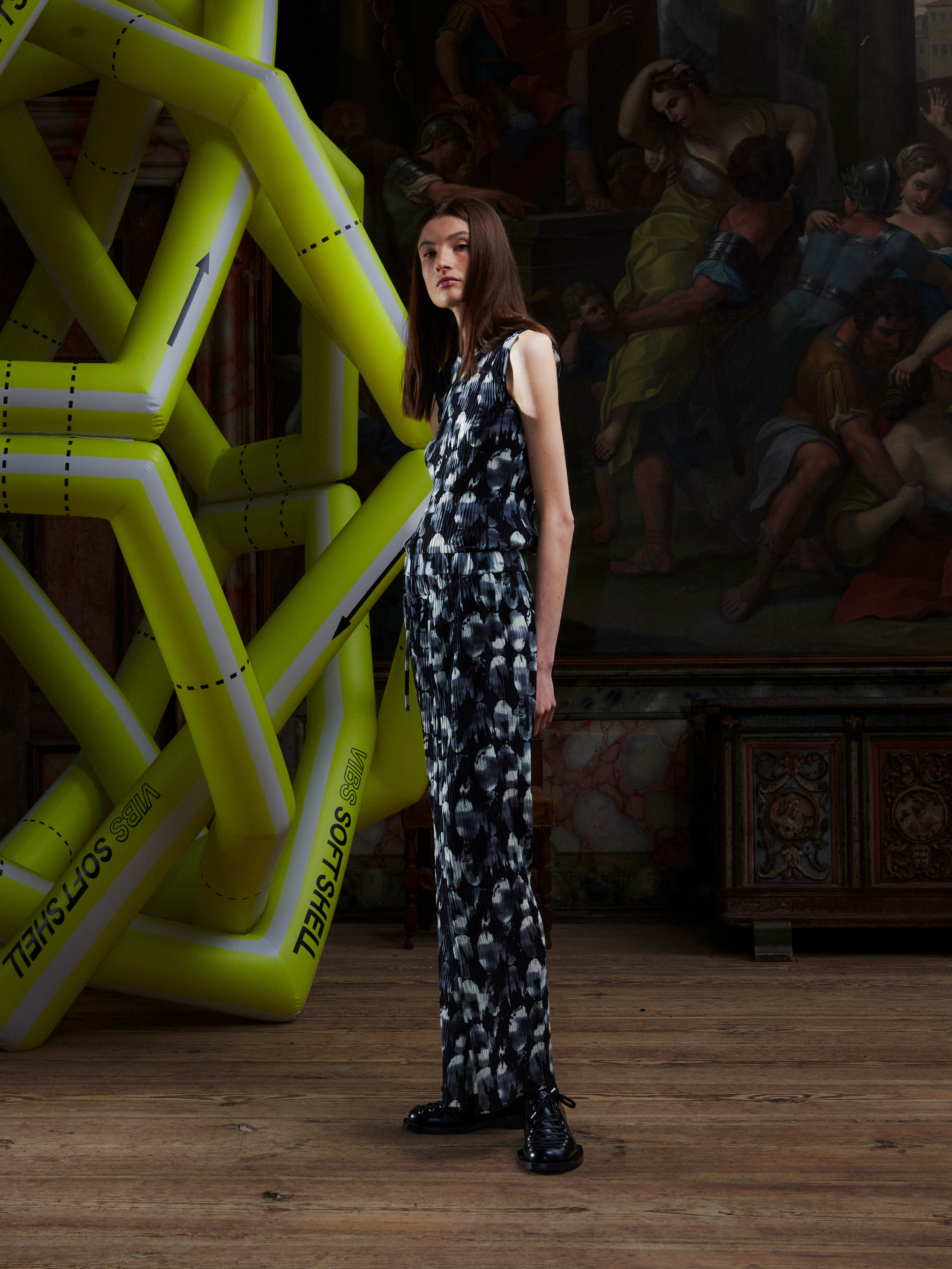 Side view of the model wearing the full plissé pants with the bursting-eggs print.