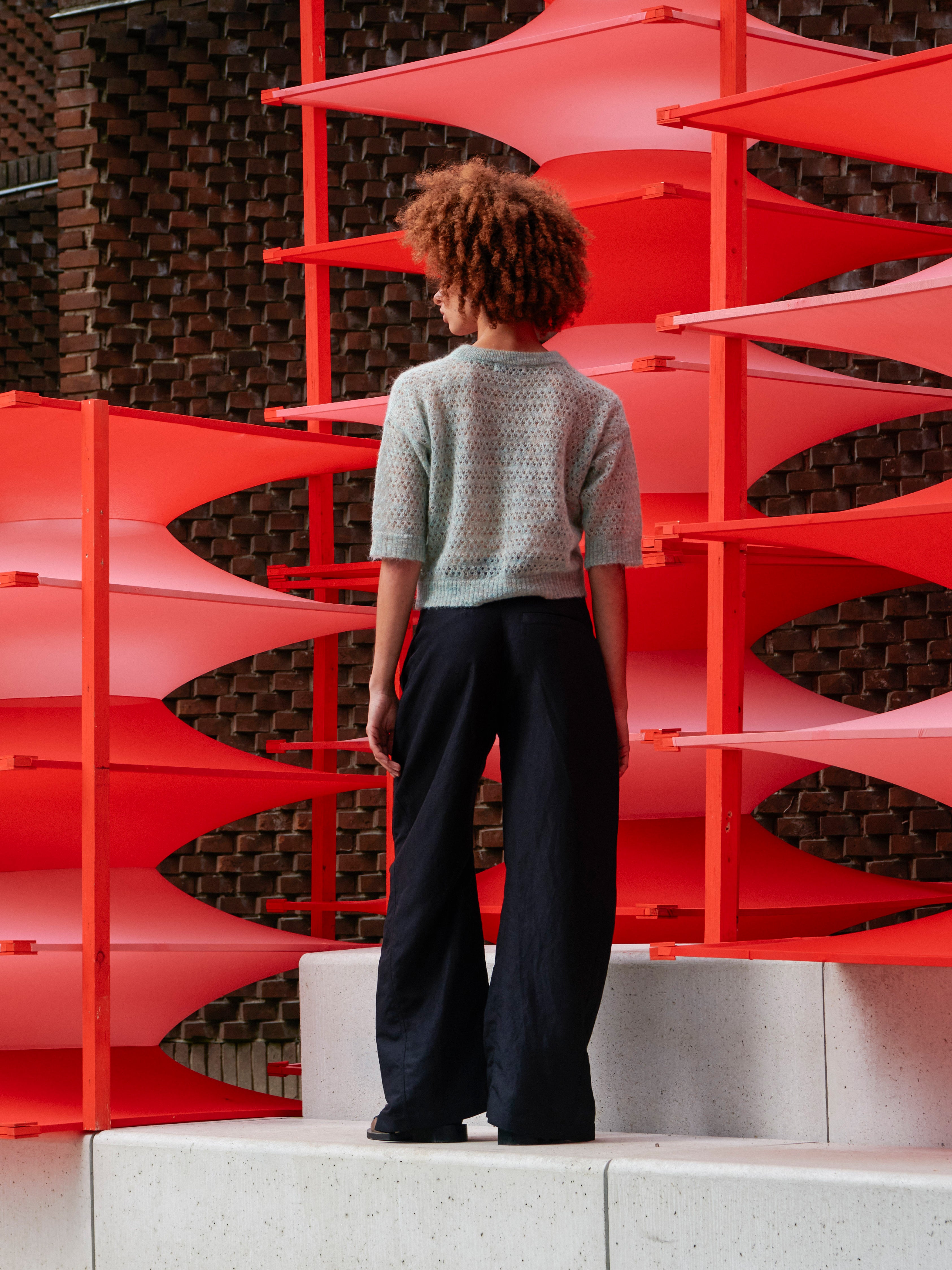 Model wearing the Hug Knit Tee in Multi Hug mint cropped knit tee with collar detail and relaxed silhouette, back view – Henrik Vibskov Spring/Summer 2026 Key Collection