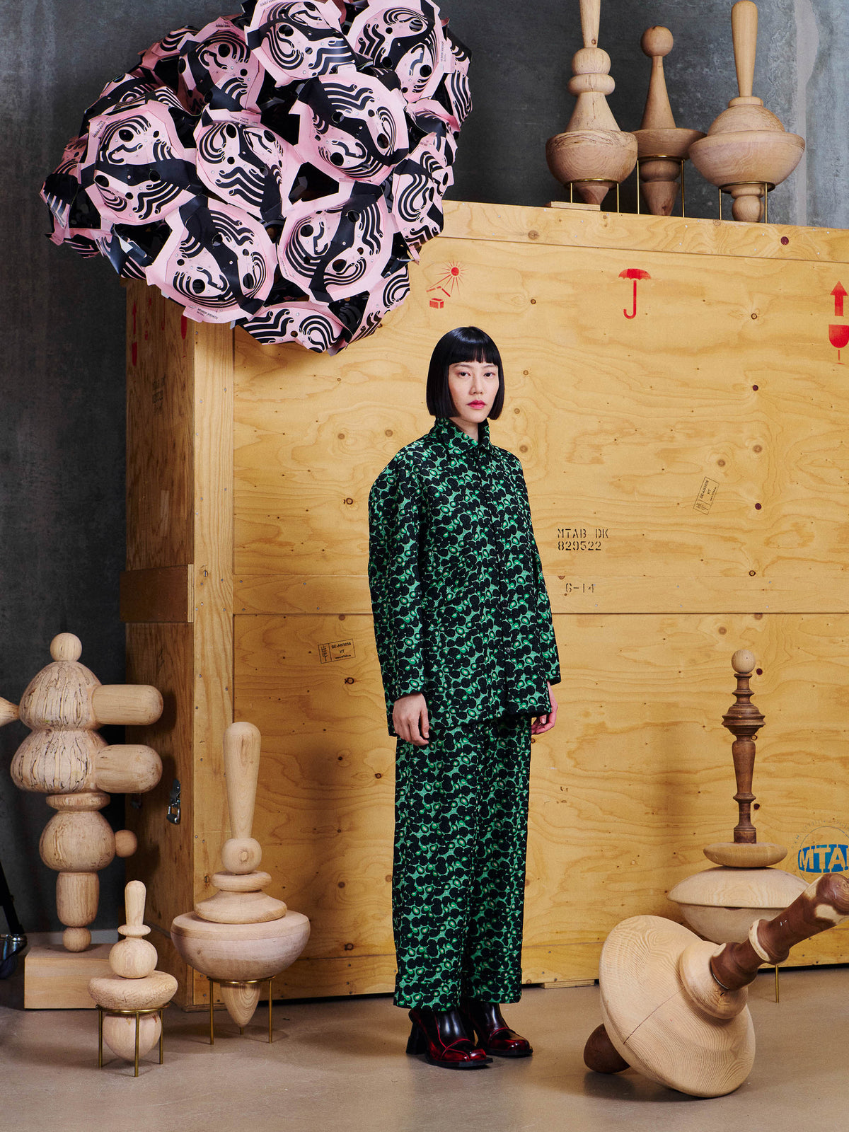 Angled view of model wearing the Henrik Vibskov Love You Blouse in Dark Green Berries, showing the long sleeves and relaxed longline shape.