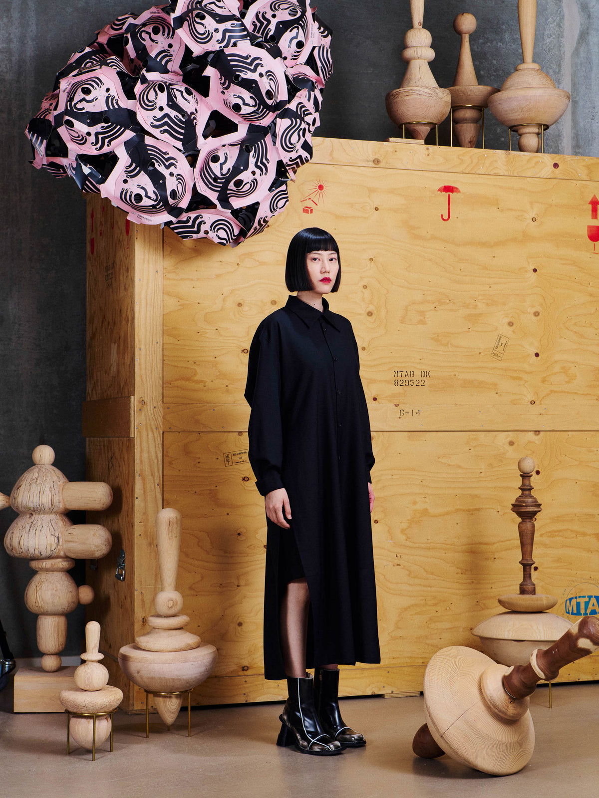 Henrik Vibskov Love You Dress in Black worn side view, showing the shirt collar, loose drape, long sleeves and high side slit.