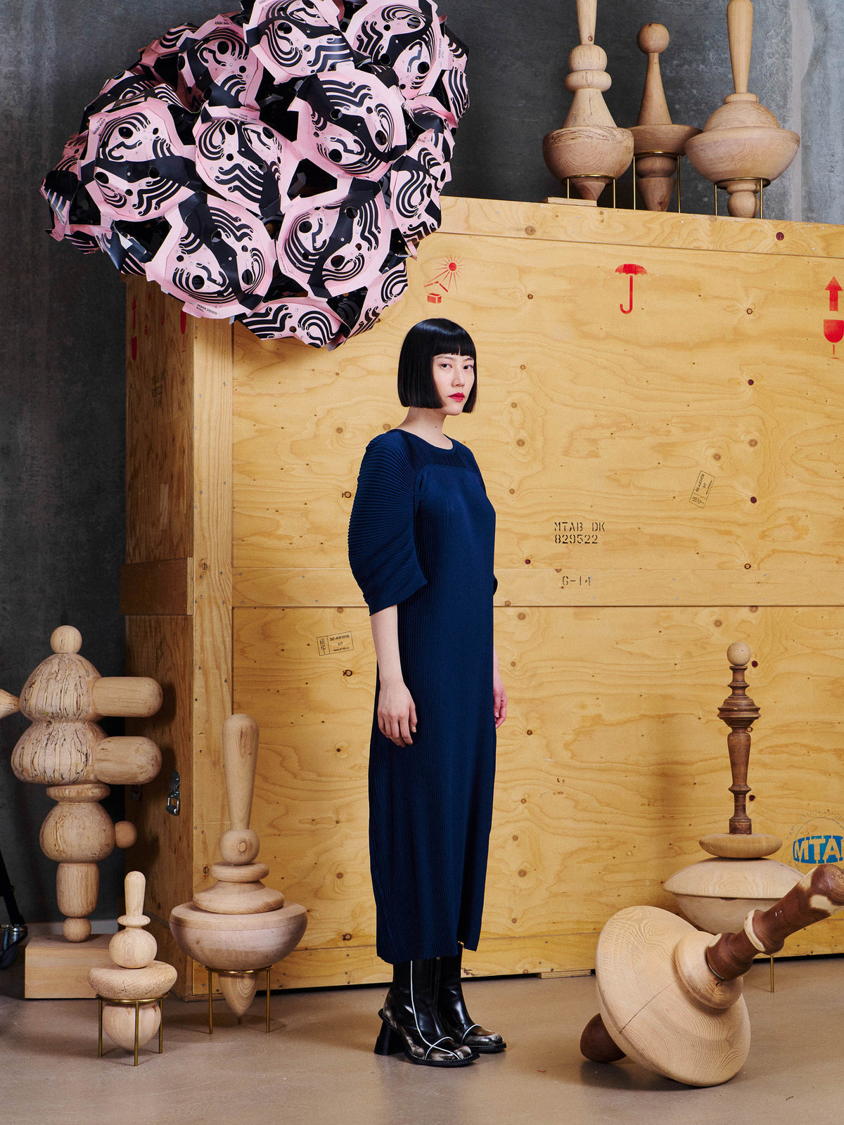 Side view of model wearing the Henrik Vibskov Lupu Plisse Dress in Dress Blues, showing the pleated texture and sculptural sleeve shape.