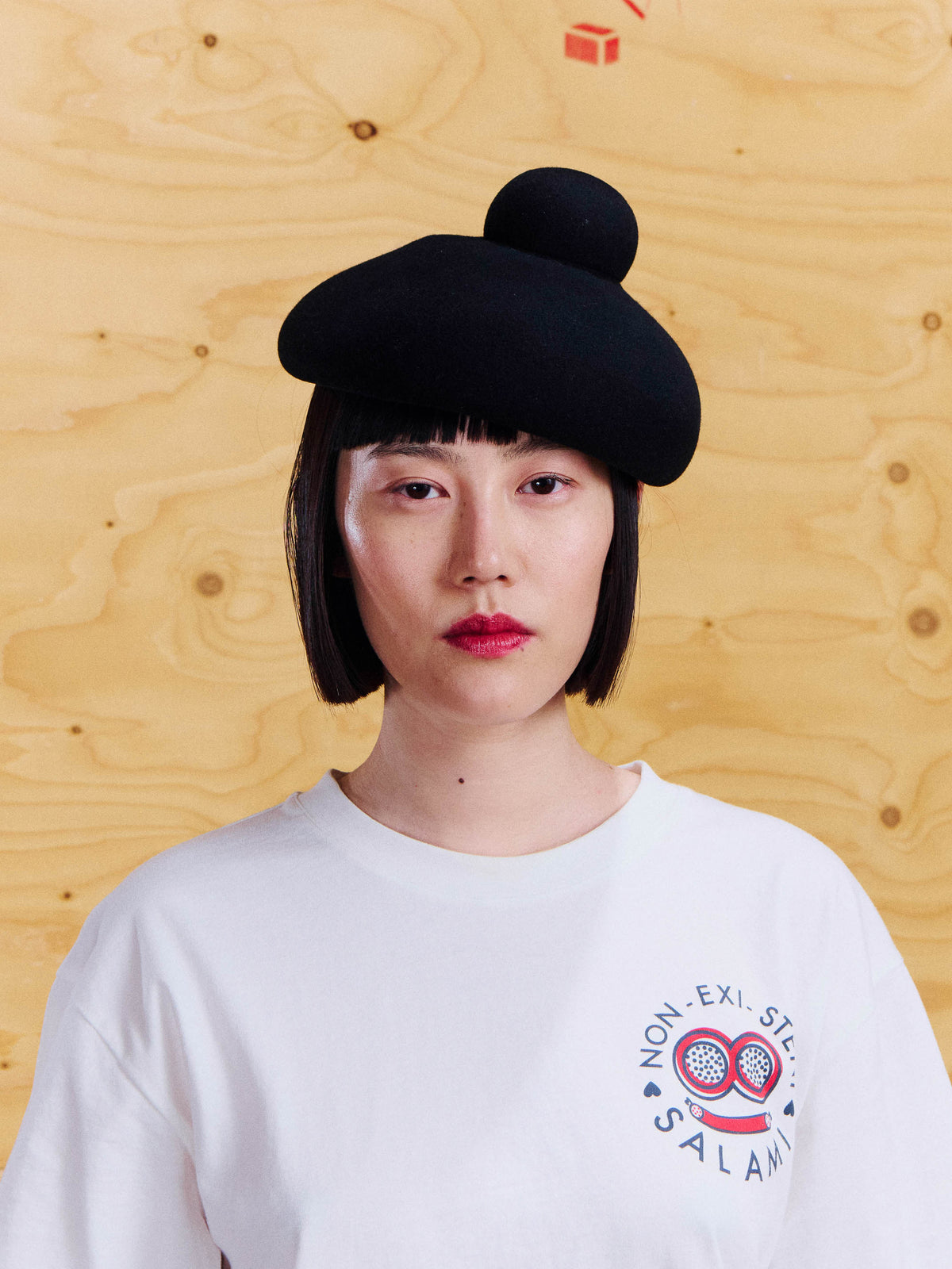 Henrik Vibskov Macaron Hat Anniversary in Black, worn view showing black felted wool shape and raised circular top detail