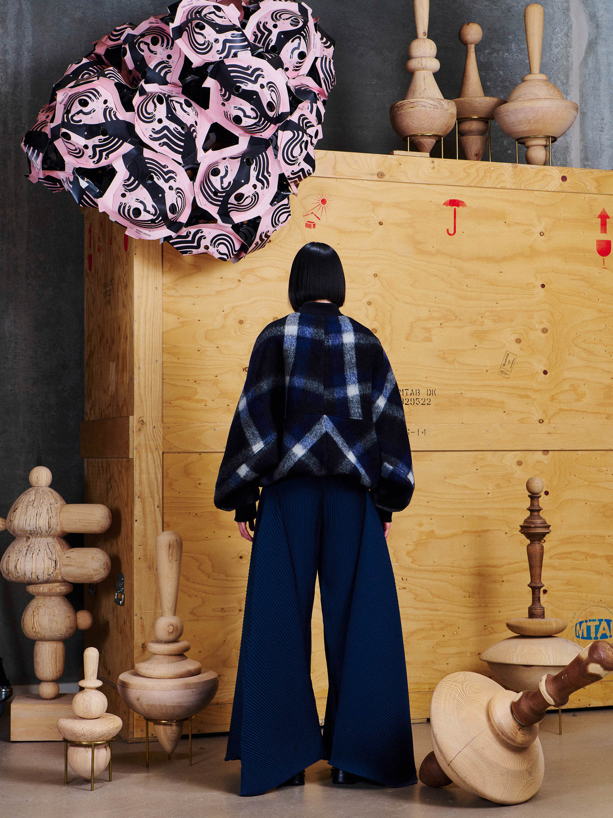 Back view of female model wearing Henrik Vibskov Merry Bomber, showing the checked back panel and ribbed hem.