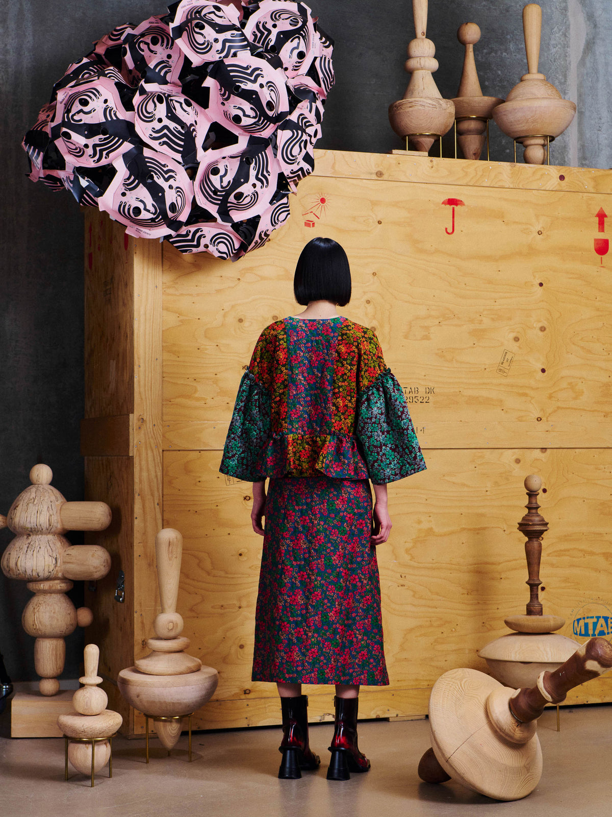 Henrik Vibskov Pumpkin Blouse in Floral Affairs styled on model from the back, showing cropped fit, wide sleeves, gathered hem and all-over floral patchwork pattern. ID: ARCHIVE-F205