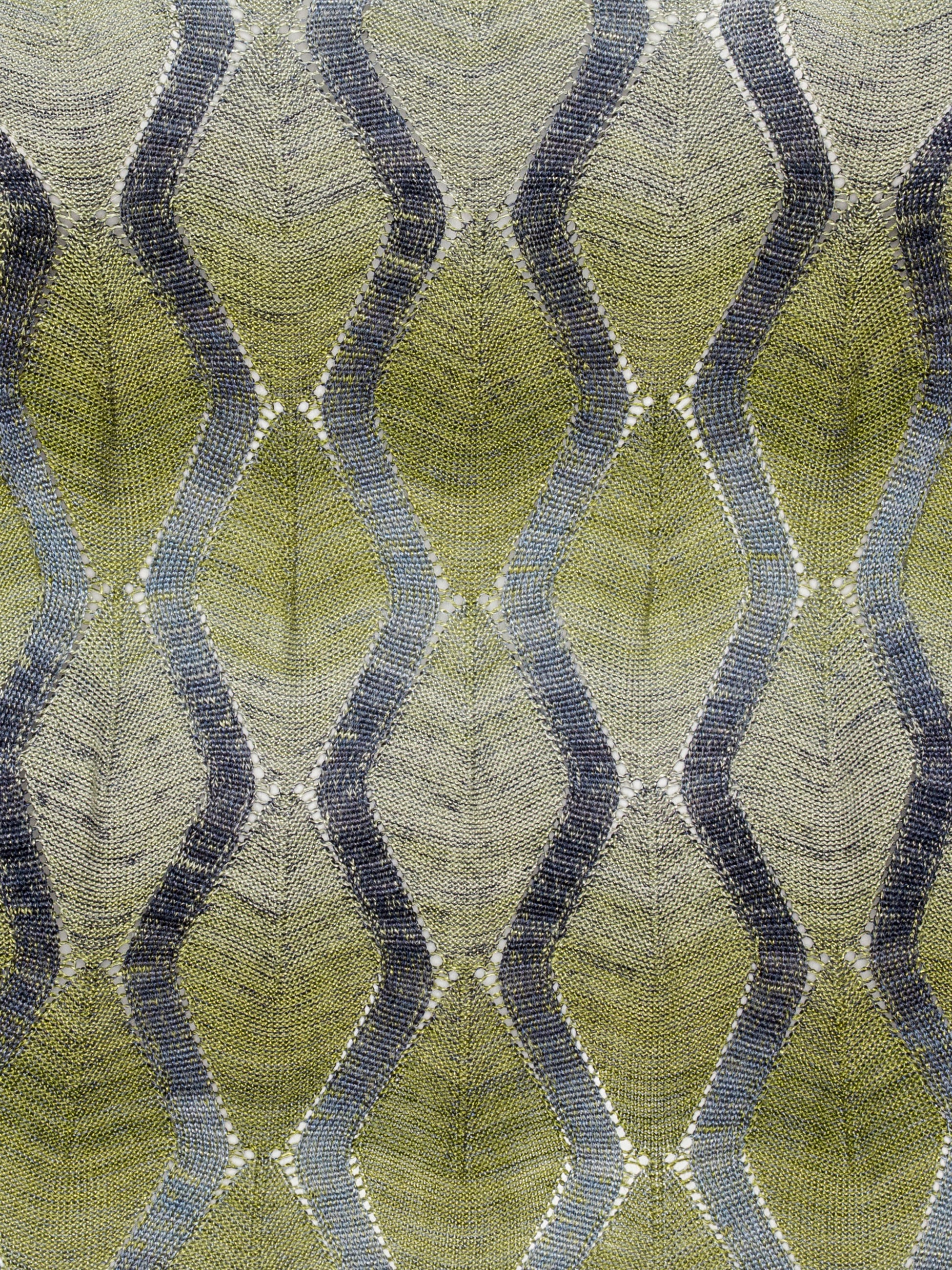 Closeup of Henrik Vibskov Resonance Top in Multi Flame, highlighting green fabric with silver pattern, ribbed hems, and form-fitting viscose texture.