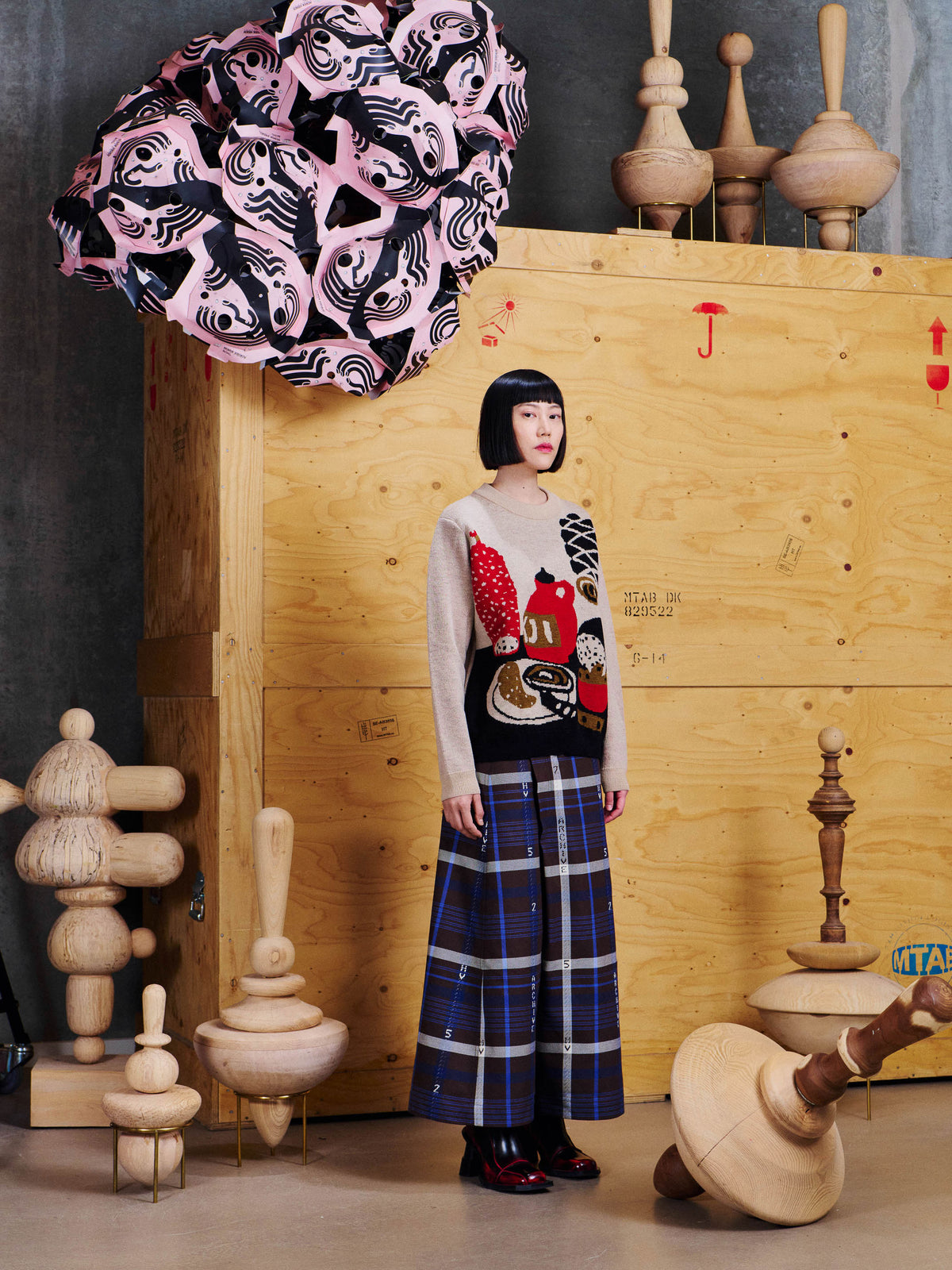 Model wearing the Henrik Vibskov Salami Knit Sweat in Table Servings, showing the straight fit and graphic knitted still-life design.