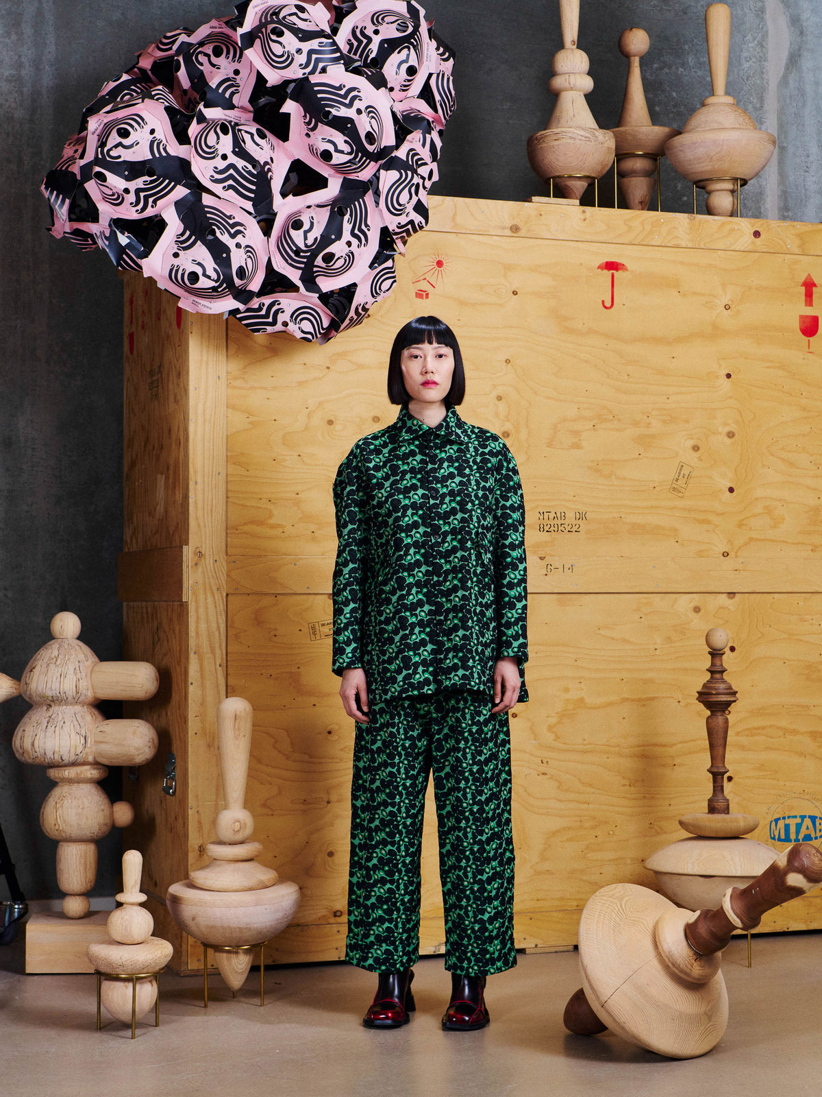 Model wearing the Henrik Vibskov Say Cotton Pants in Dark Green Berries with the matching shirt, showing the relaxed wide-leg silhouette.