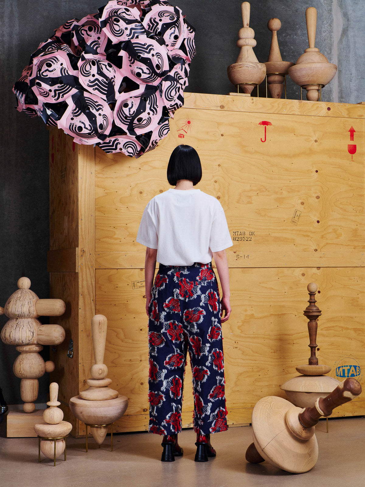 Henrik Vibskov Say Cotton Pants in Red Navy Birdy worn back view with a white T-shirt, showing the cropped straight-leg shape and all-over raised bird motif.
