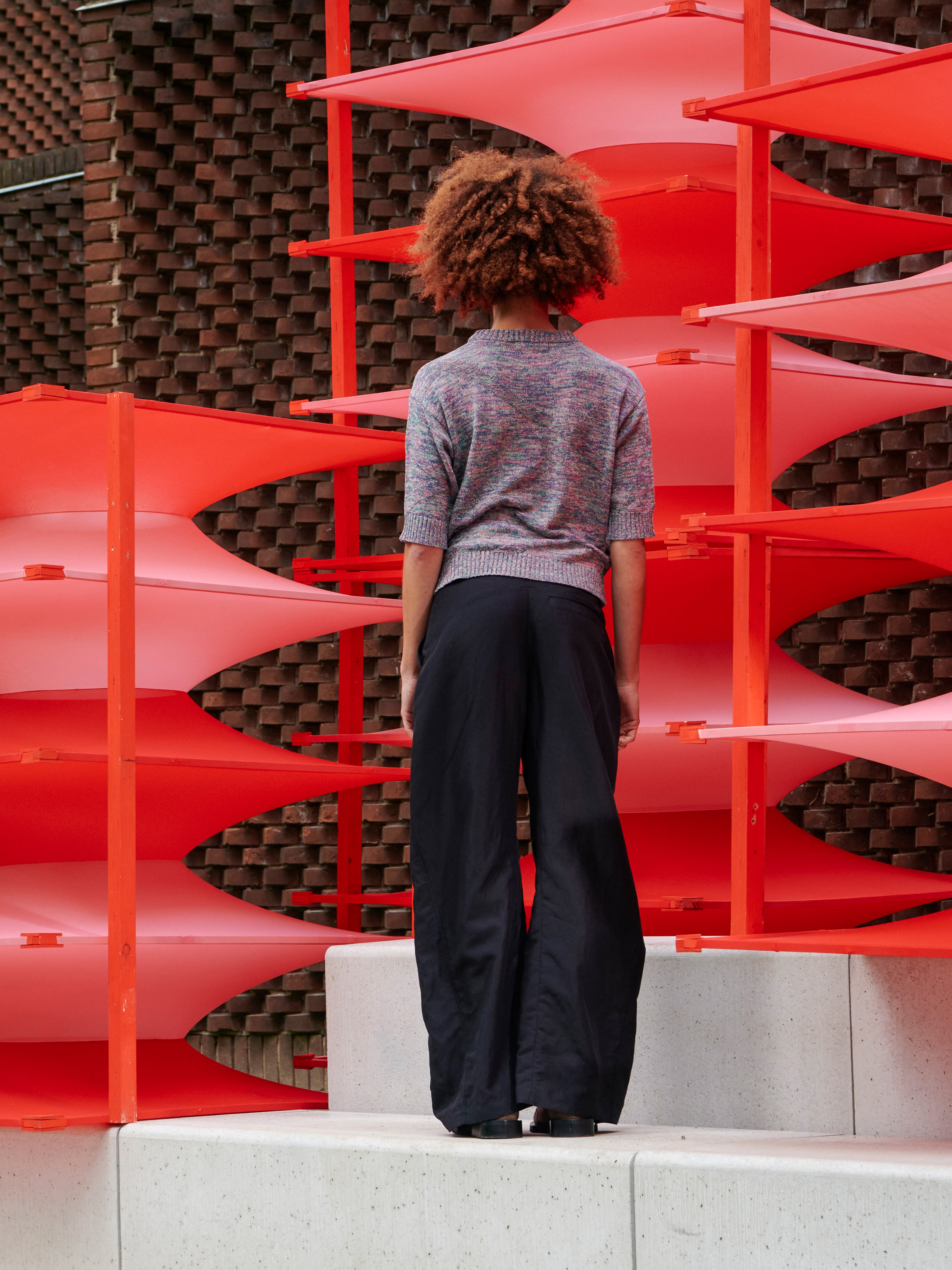 Model wearing the Silk Net Blouse in Multi Papavero mix colour cropped boxy knit with zig zag texture detail and ribbed hems, back view – Henrik Vibskov Spring/Summer 2026 Key Collection