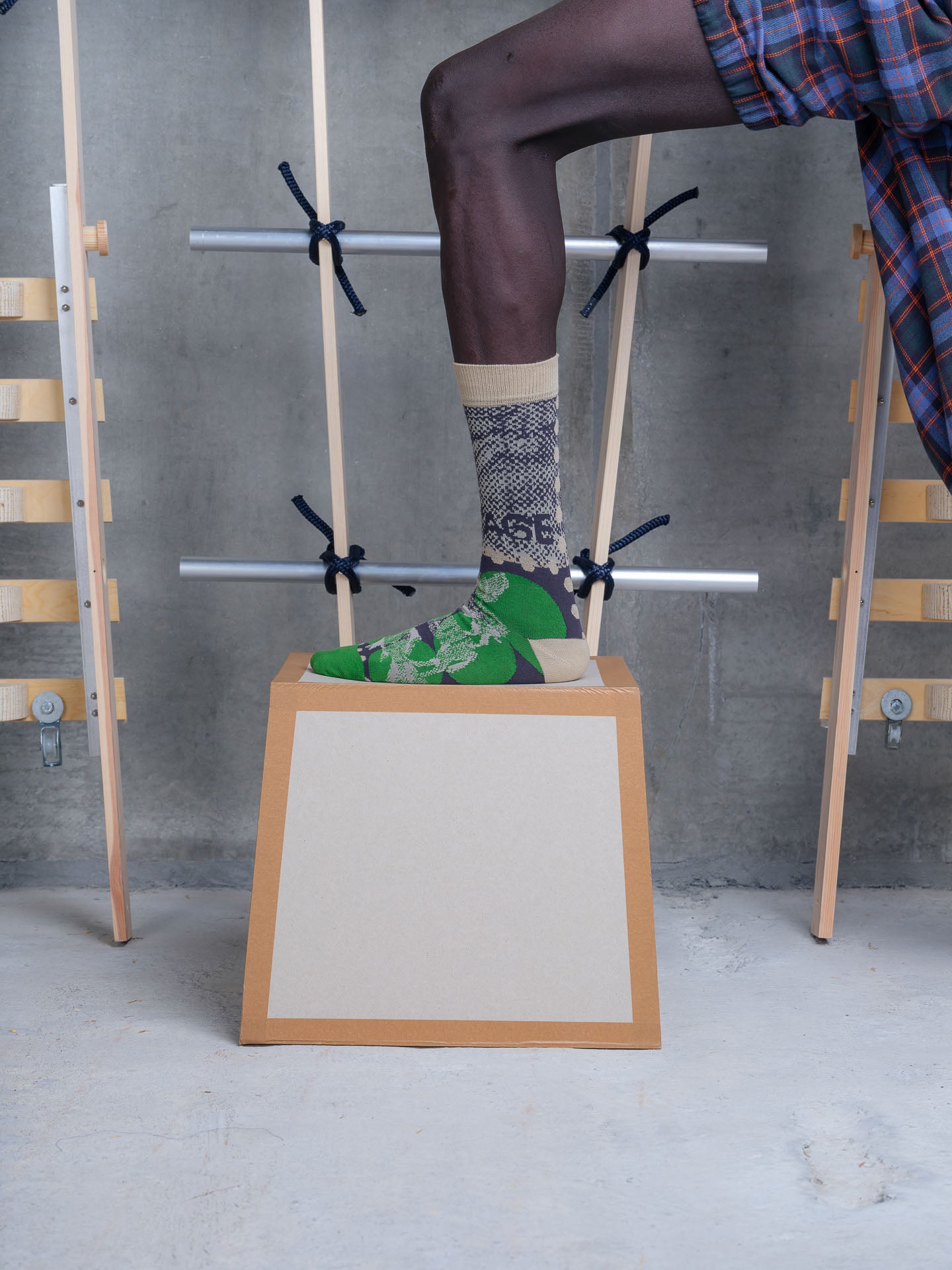 Model wearing the Henrik Vibskov Tower Sock in Postage Green Dots, close-up side view