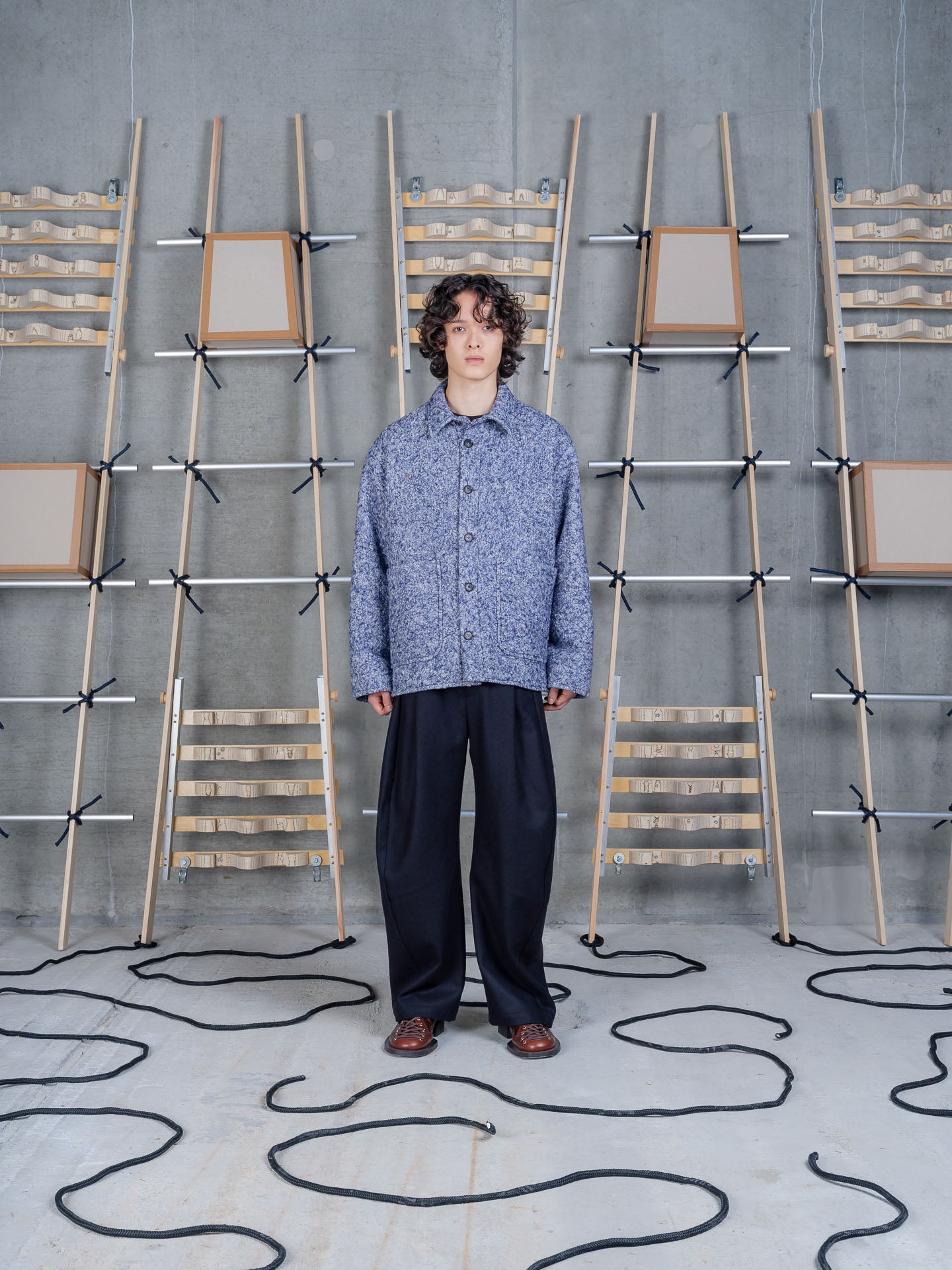 Henrik Vibskov Wheel Jacket in Blue Pebbles worn on model, full-length front view, bouclé wool blend chore jacket styled with navy trousers