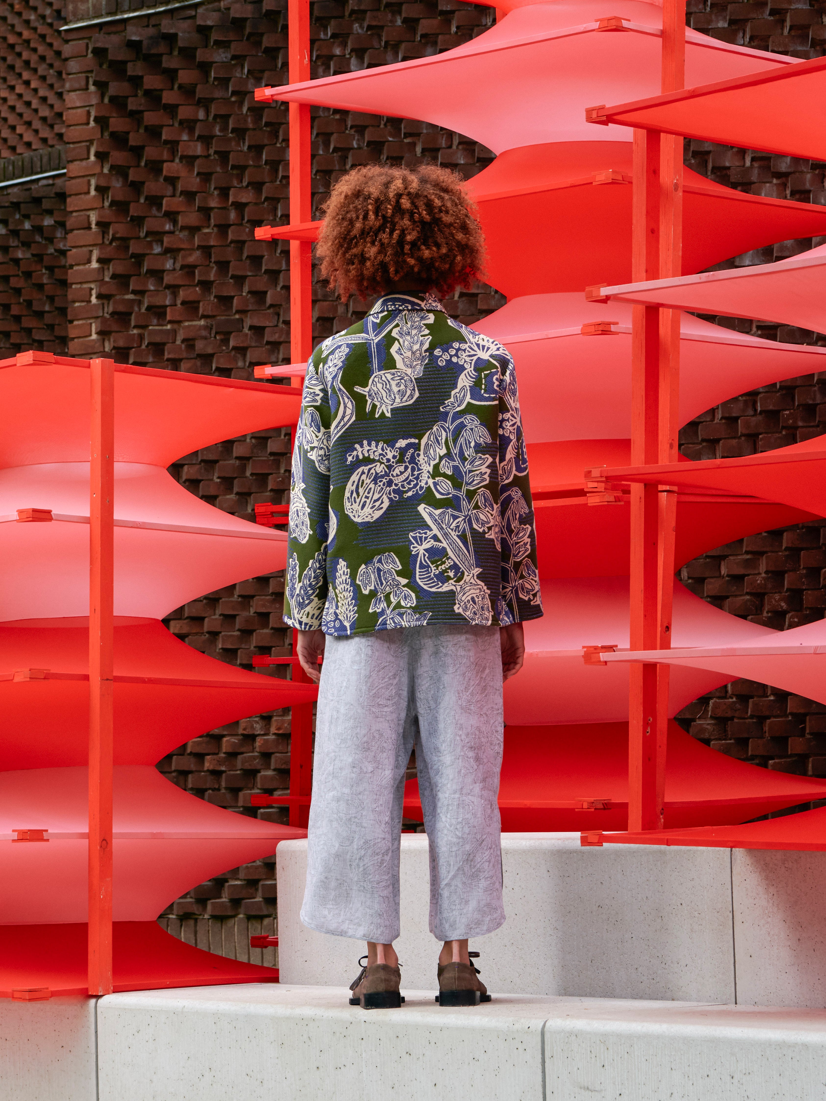 Model wearing the Wheel Jacket in Garden of EEden green blue and white floral boxy jacket with straight hem and long sleeves, back view – Henrik Vibskov Spring/Summer 2026 Key Collection